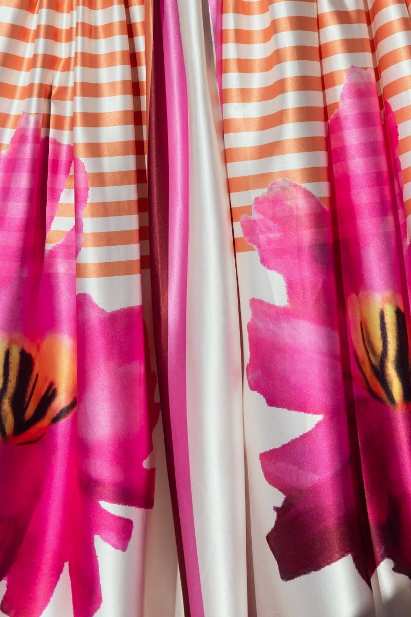 Close-up of Flaria Maxi Dress featuring vibrant pink floral design and striped fabric.