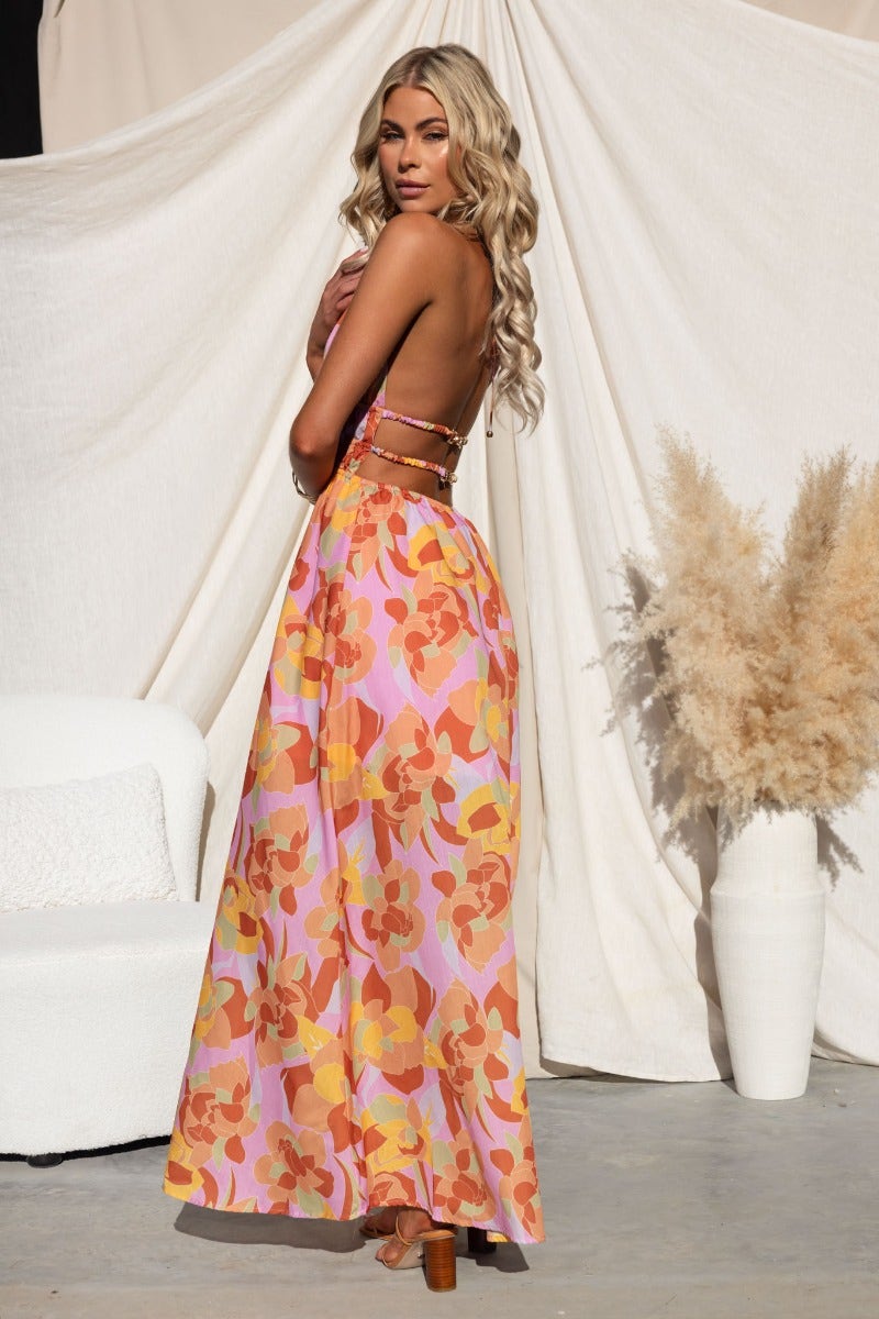 Model wearing Kariah Maxi Dress, a multi-colour floral maxi dress with adjustable tie halter neckline and cut-outs.