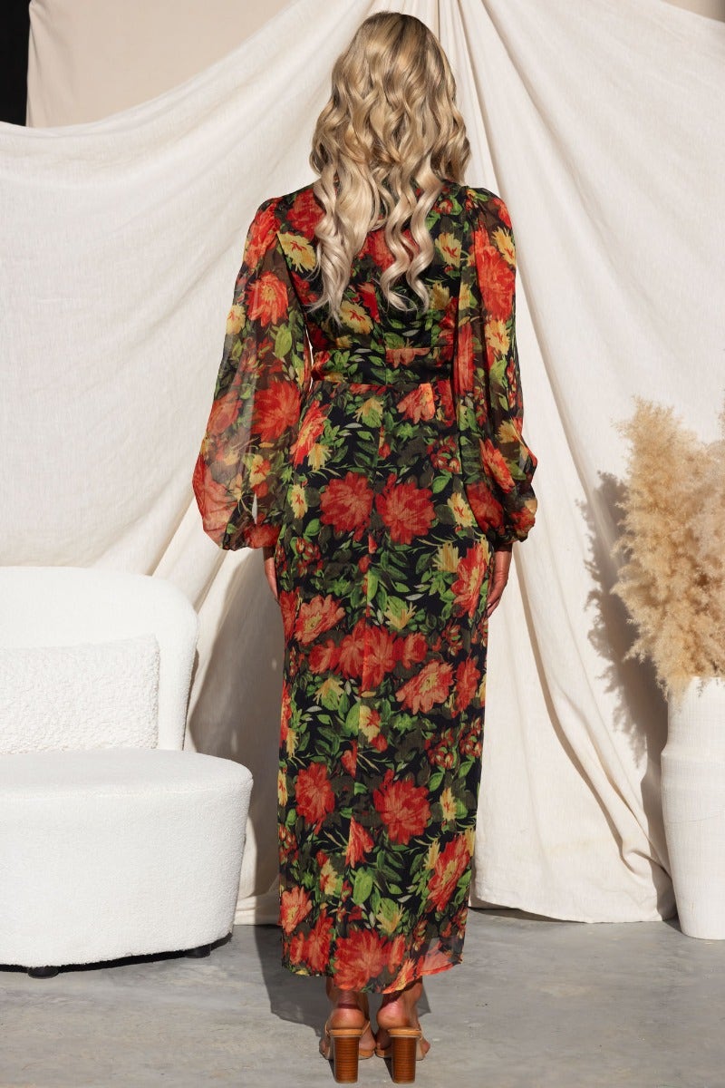 Model wearing Mietta Maxi Dress with floral print, showing back view and flowing sleeves against a neutral backdrop.