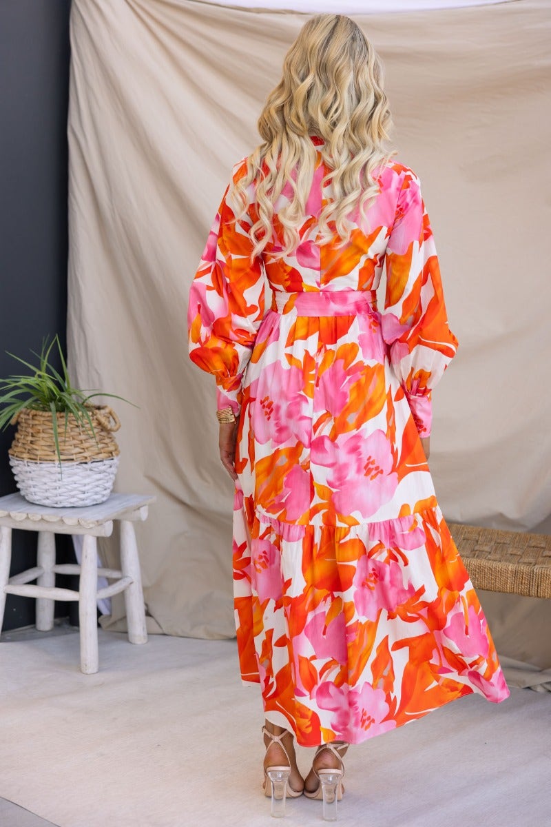 Model wearing Ikoma Maxi Dress with vibrant floral print, high neckline, and cut-out detail, perfect for summer occasions.