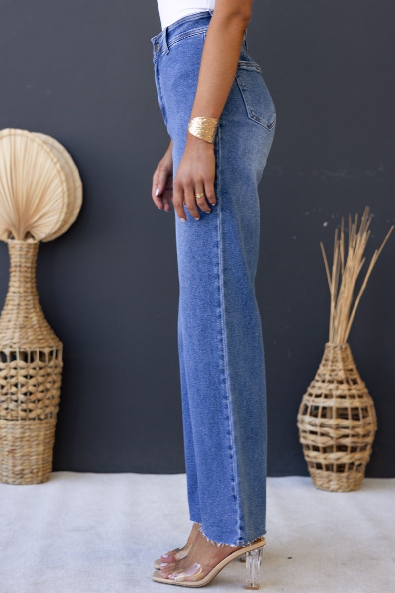 Timberlake Jeans showcasing mid-high waist fit, wide legs, and pockets, styled with a modern touch and natural decor.