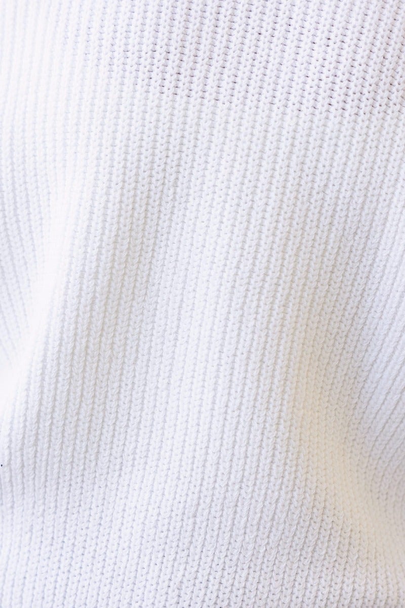 Close-up of Kallan jumper fabric featuring a textured white knit pattern with ribbed detail.