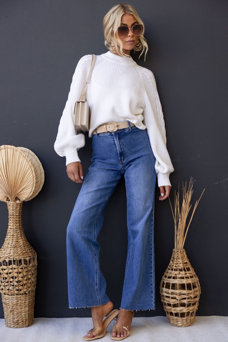 Model wearing Timberlake Jeans with mid-high waist and wide legs, styled with a white sweater and accessories.