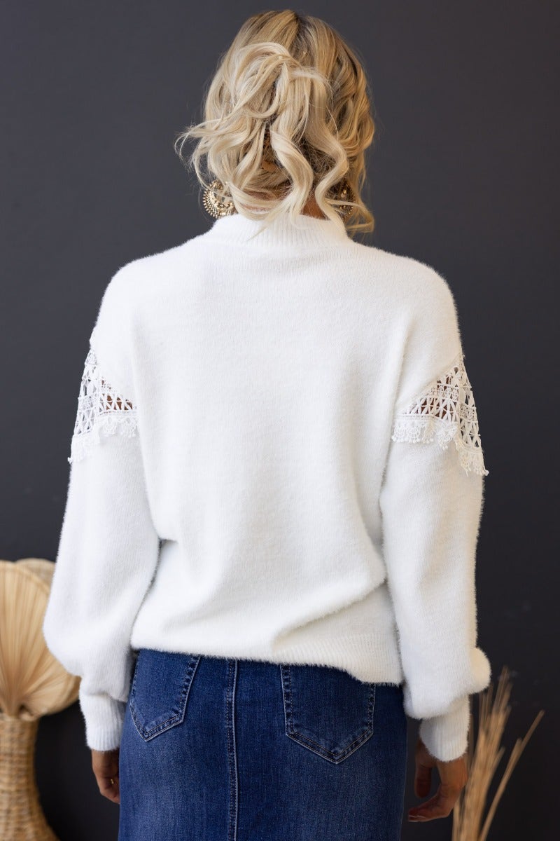 Back view of white Kyoto Jumper with lace detail, featuring high neckline and slightly relaxed fit on model.