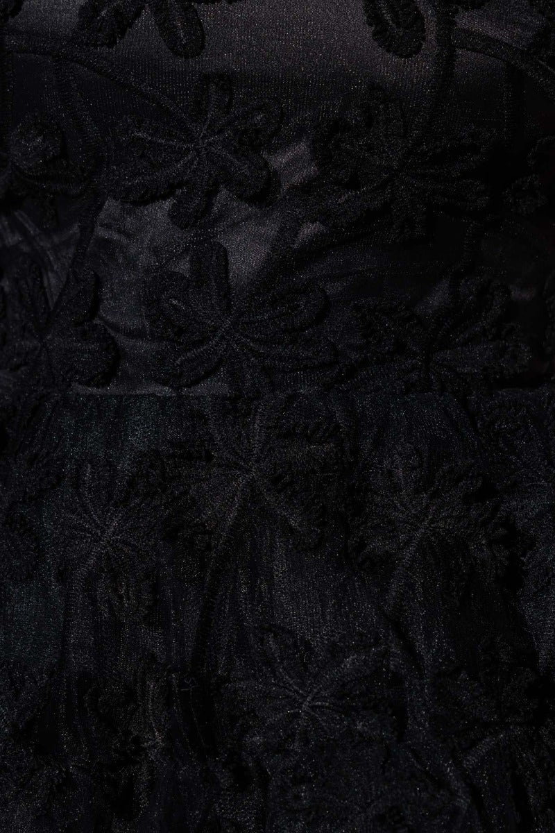 Close-up of black textured fabric featuring intricate floral embroidery, ideal for an elegant strapless dress.