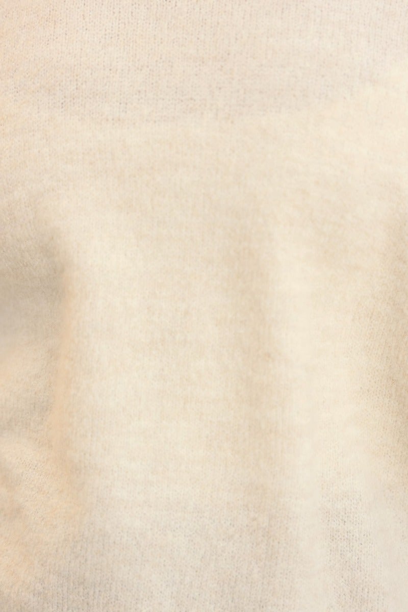 Close-up of Keilor Jumper showing soft, open weave knit texture and cream color, perfect for a relaxed fit.