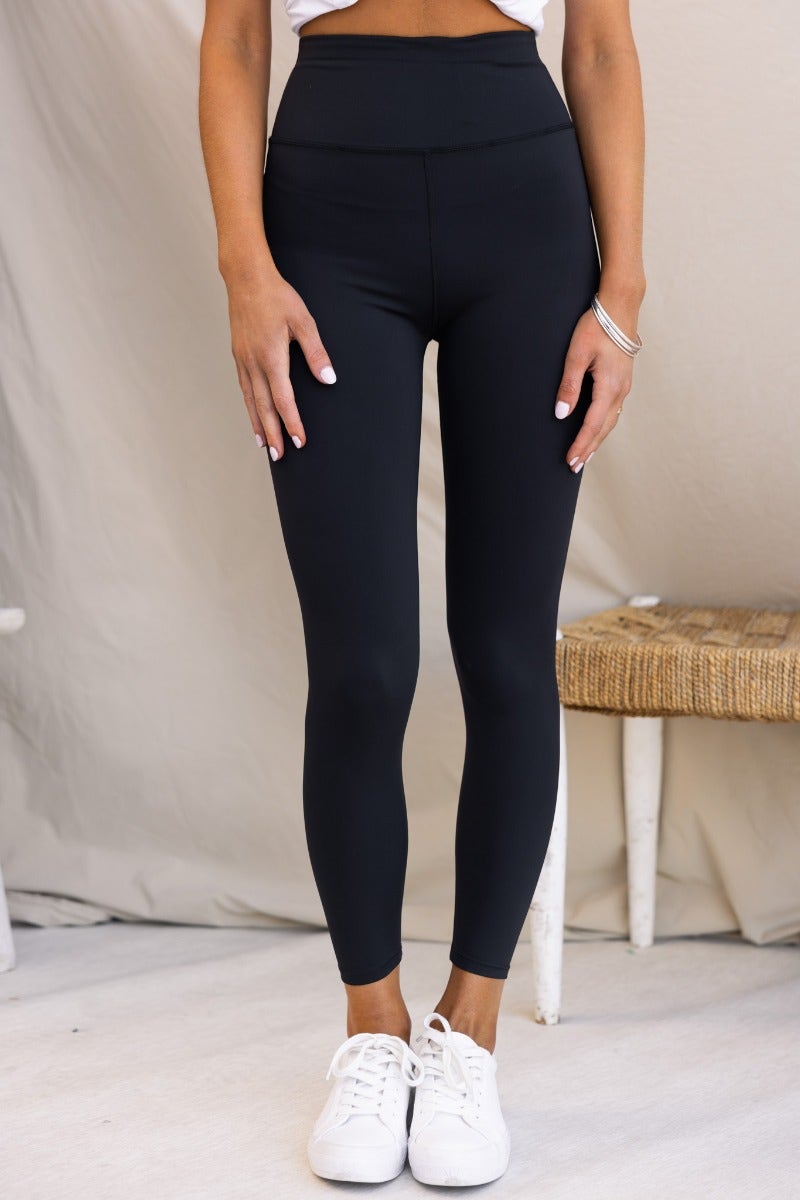 Mally black leggings with mid-high waist, wide waistband, and firm stretch material, perfect for casual wear or workouts.