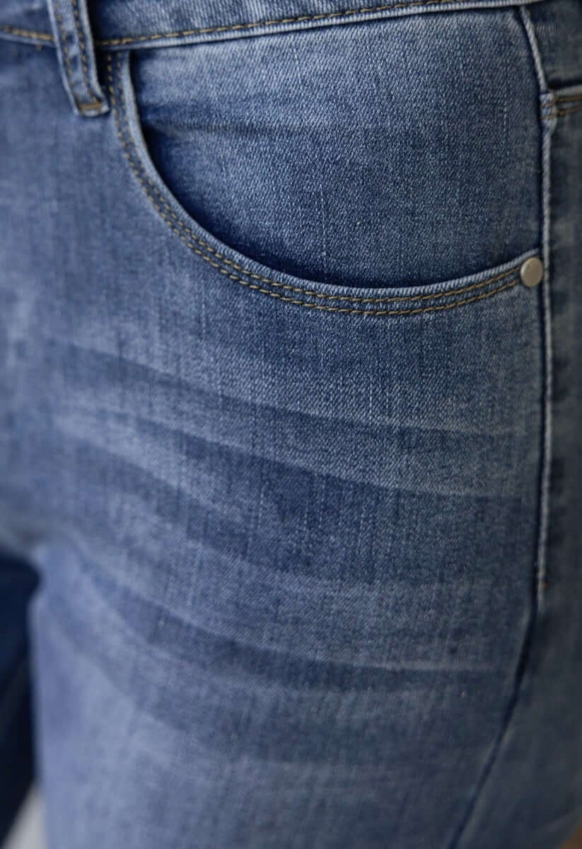 Close-up of Qilli Jeans showing distressed denim fabric, pocket detail, and raw hem for stylish casual wear.