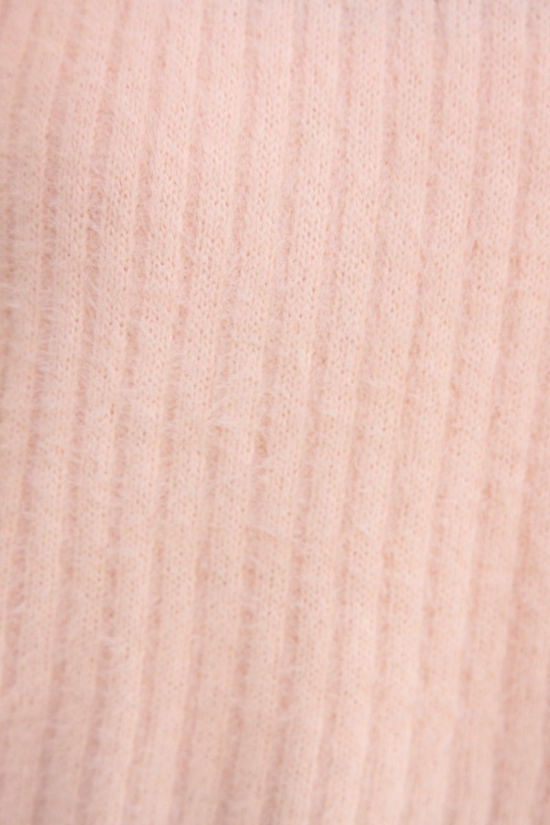 Close-up of soft, fluffy knit fabric in pale pink with subtle ribbing texture, perfect for a cozy jumper.