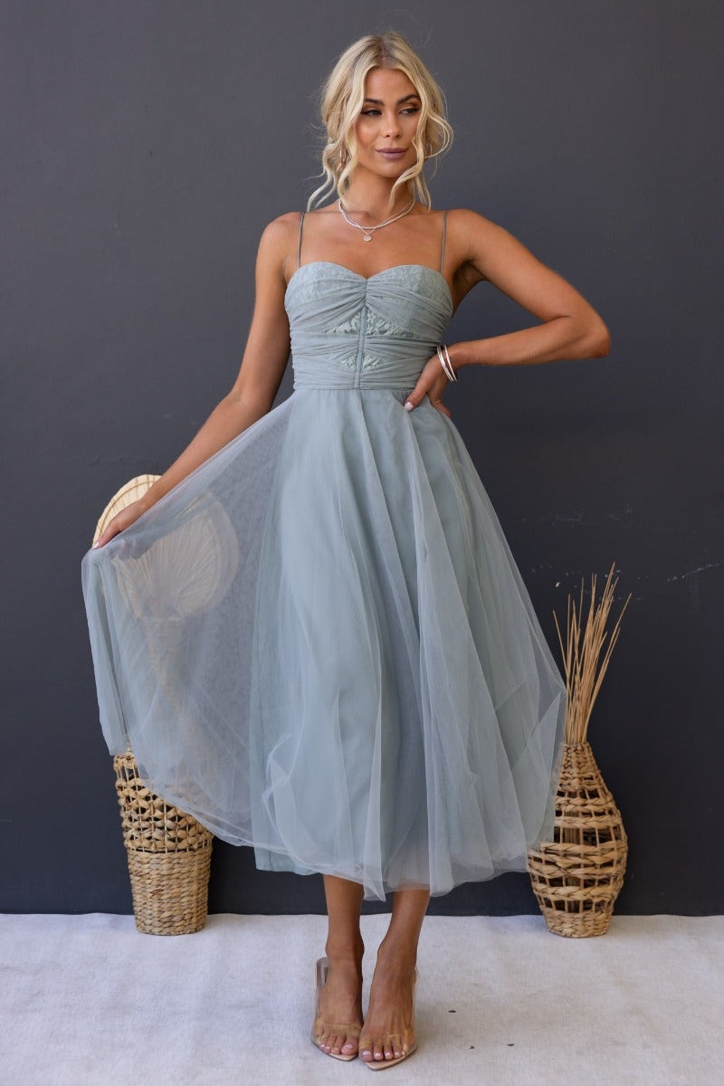 Genevie midi dress featuring adjustable straps, padded bust, and tulle skirt in soft green color.