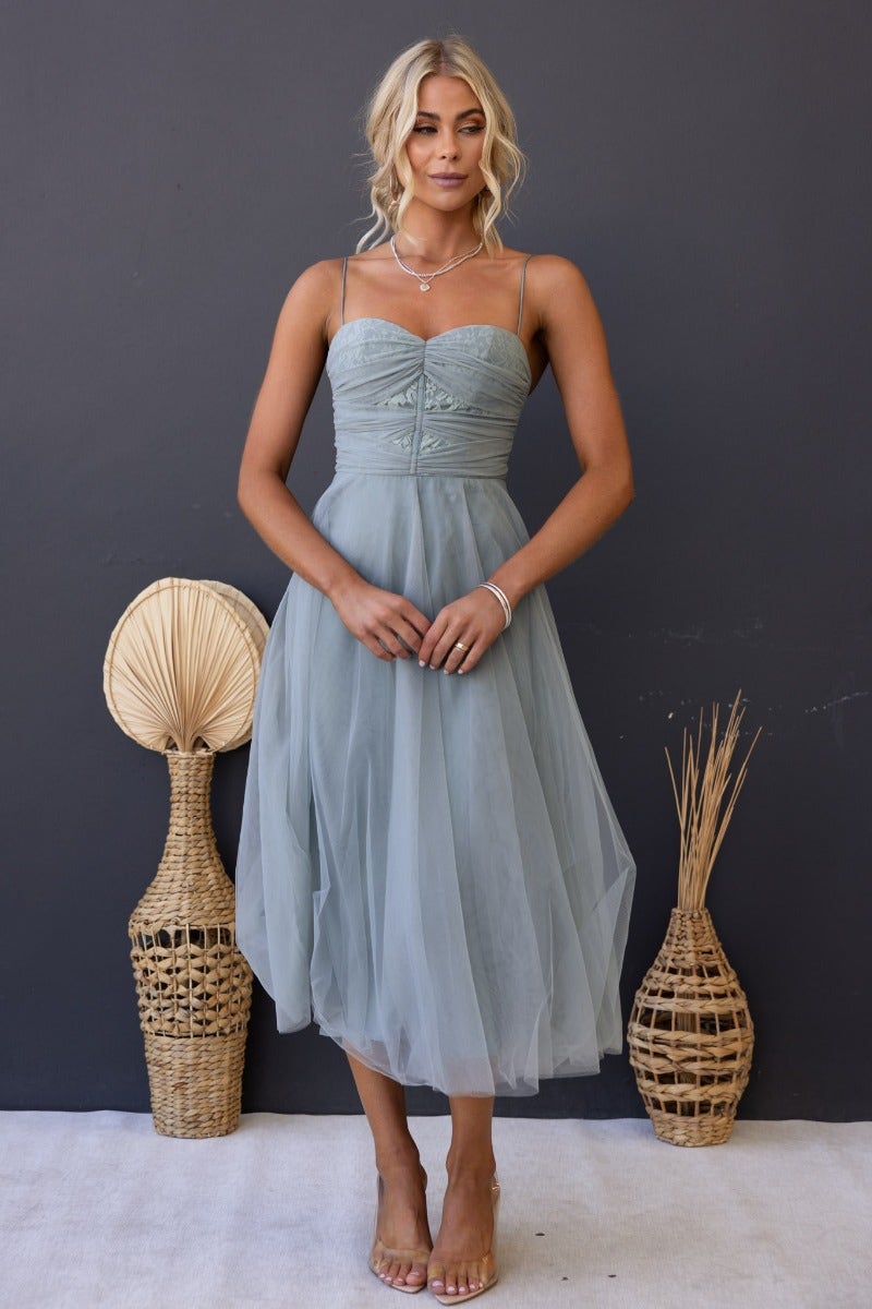 Genevie midi dress in light green tulle with adjustable straps and padded bust, styled for a casual look.
