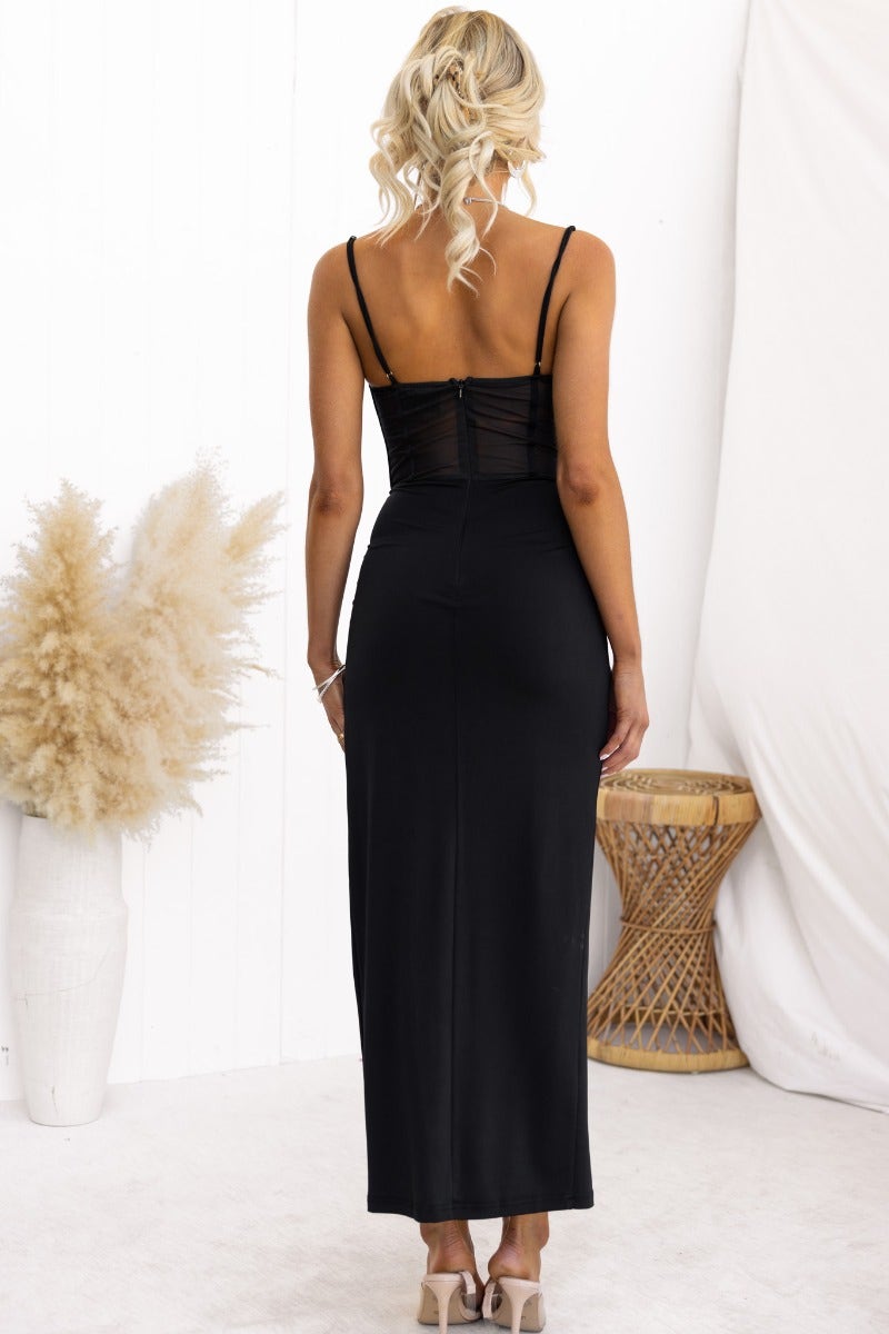 Back view of Havilah black midi dress with padded bust, sheer mesh panel, and split at front.