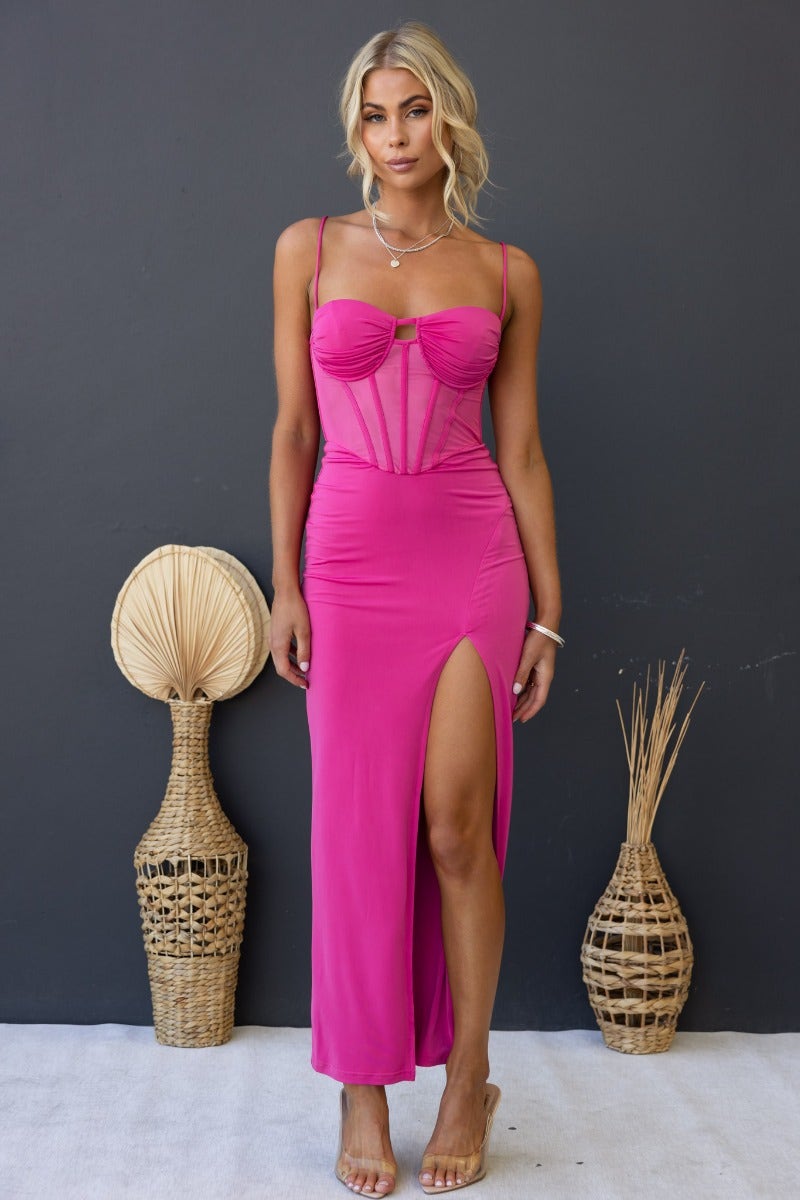 Havilah Midi Dress in fuchsia with padded bust, sheer mesh panel, and front split, styled with accessories.
