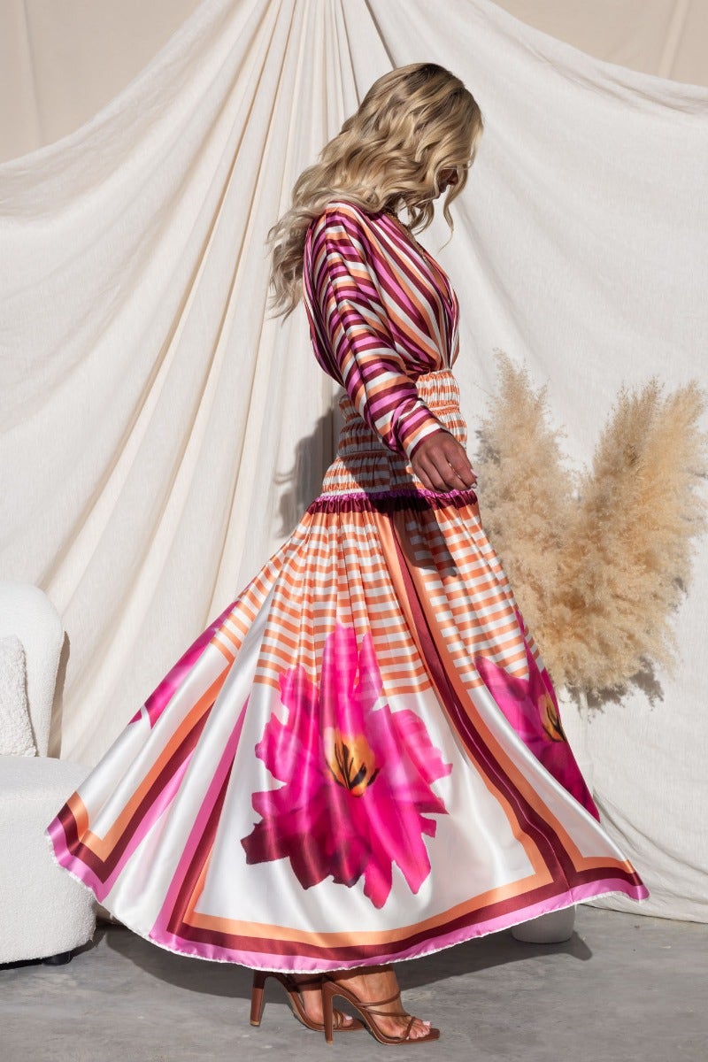 Model in Flaria Maxi Dress featuring a vibrant floral design and flowing silhouette, perfect for summer occasions.