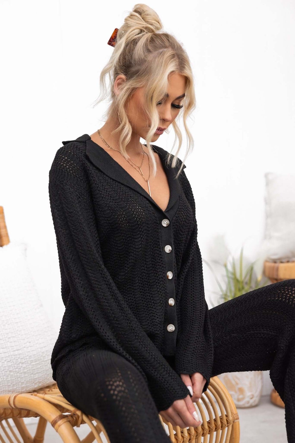 Model wearing a black Moline shirt in knit material, featuring a button-up front and relaxed fit.