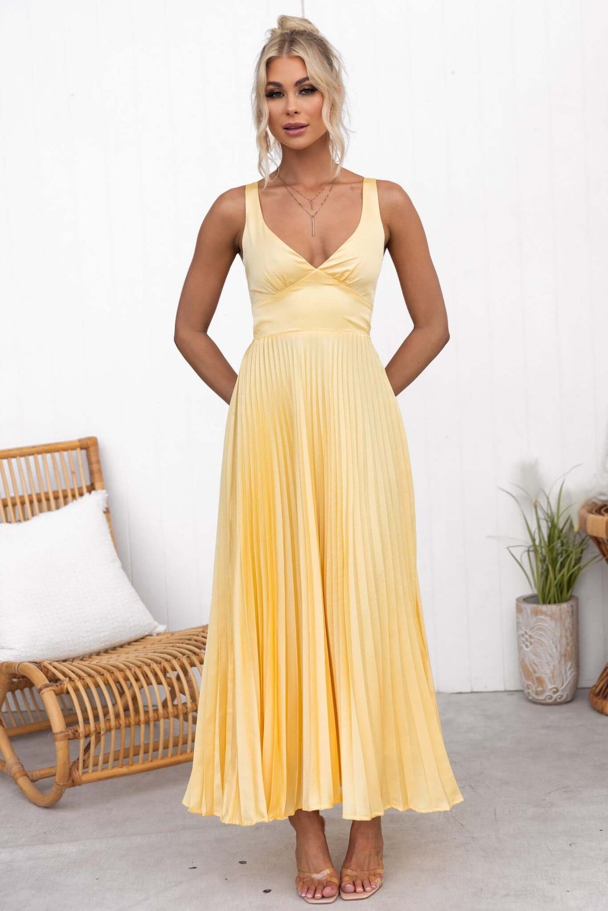 Janisse Maxi Dress in soft yellow with V-neckline, pleated skirt, and adjustable straps, perfect for summer occasions.