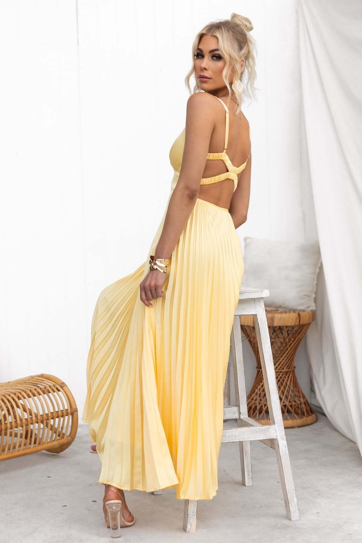 Janisse Maxi Dress in yellow with pleated skirt, V-neckline, and adjustable straps. Perfect for summer events.