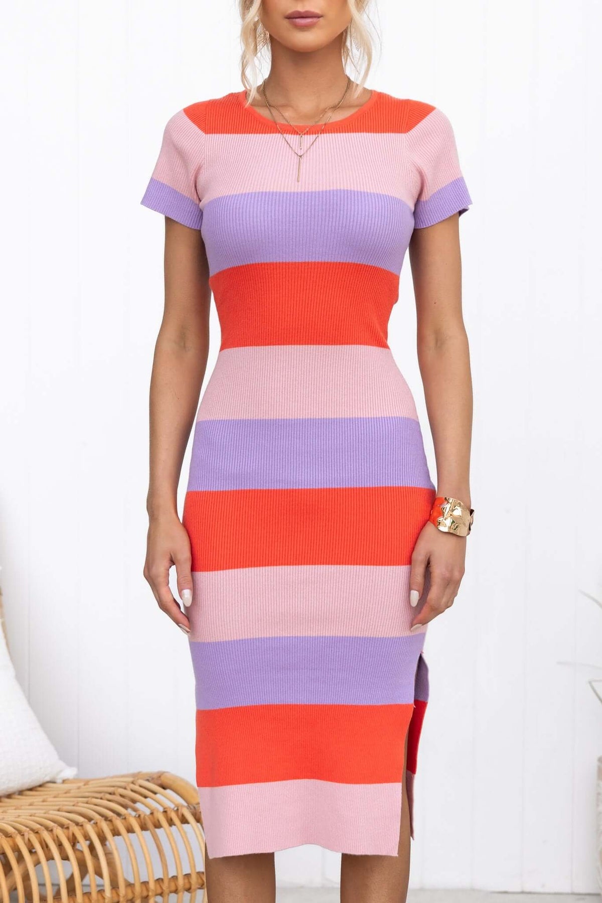 Bahlo Midi Dress featuring ribbed knit material, round neckline, side splits, in vibrant stripes of pink, red, and purple.