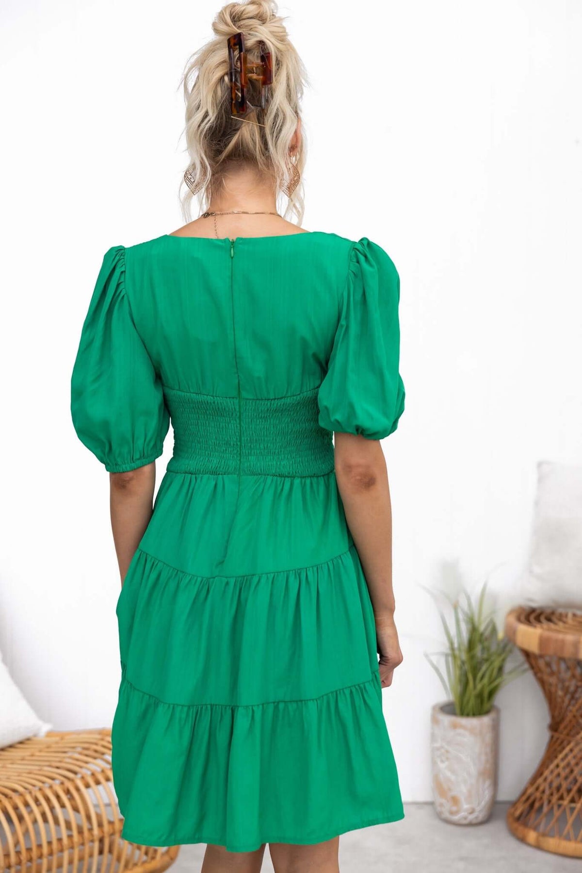 Back view of a green Sakura dress featuring puff sleeves, smocked waist, and a tiered skirt, showcasing a relaxed fit.