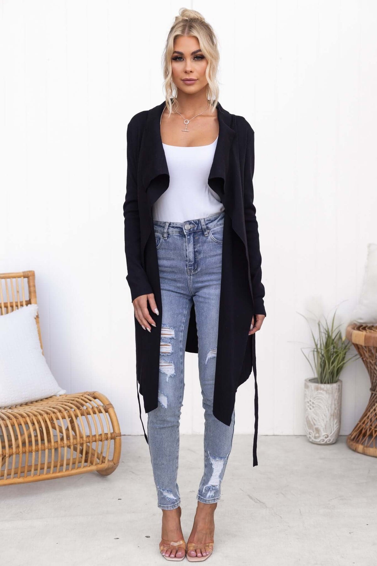 Model wearing Acaia Cardigan in black, paired with distressed jeans and heels, showcasing a relaxed fit and stylish design.