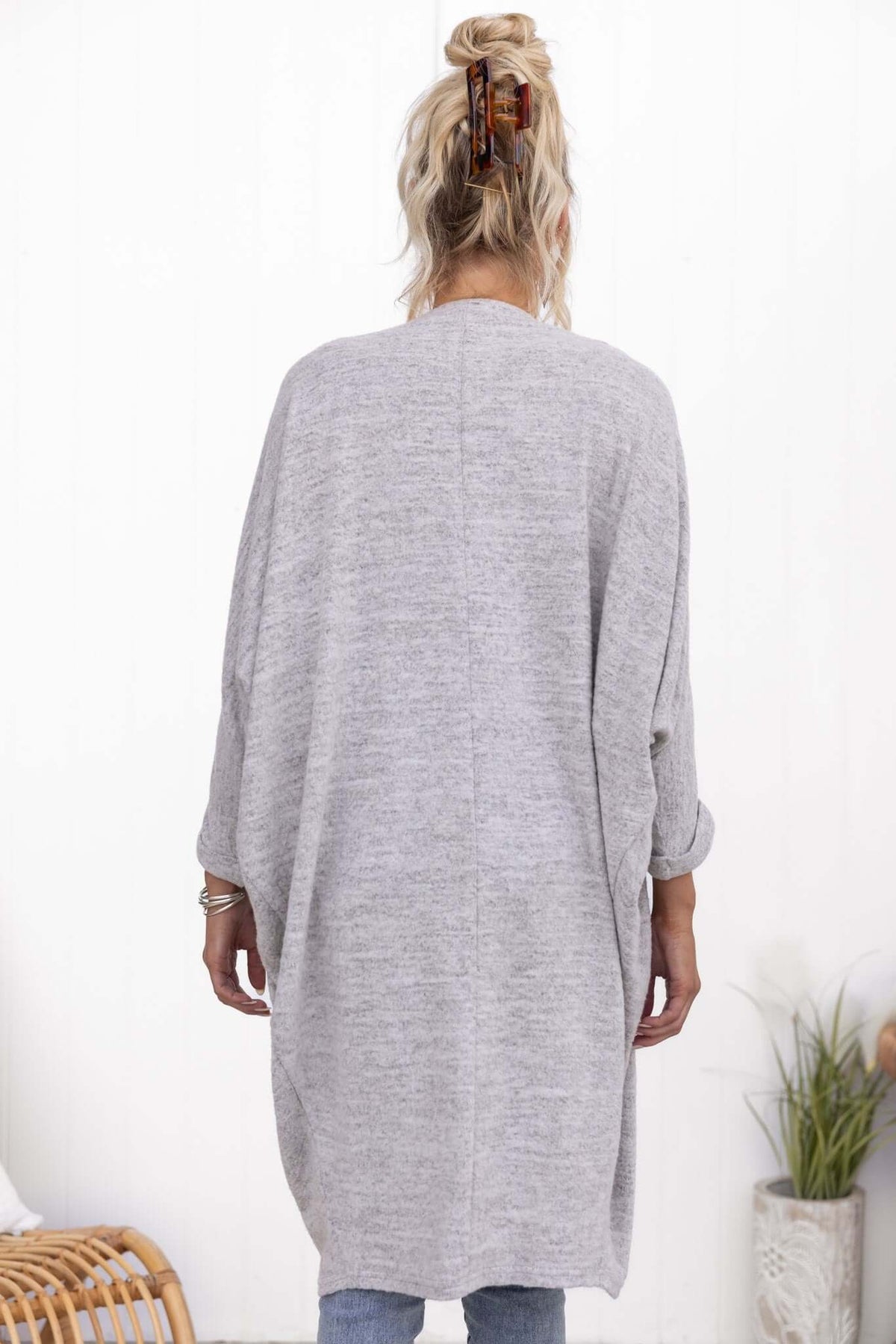Back view of a woman wearing a soft, oversized gray Right Time Cardigan with rolled cuffs and relaxed fit.
