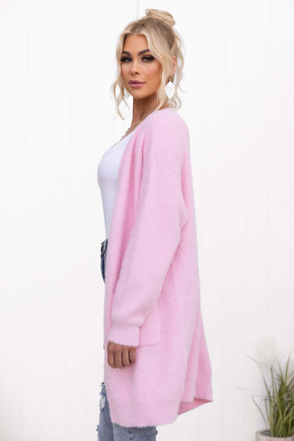 Model wearing a pink Shai Cardigan, featuring a longline fit, fluffy knit material, and pockets.