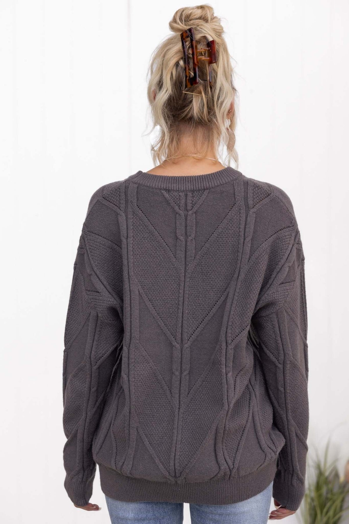 Becker Jumper in charcoal gray, featuring a round neckline and textured cable knit design, styled with casual jeans.