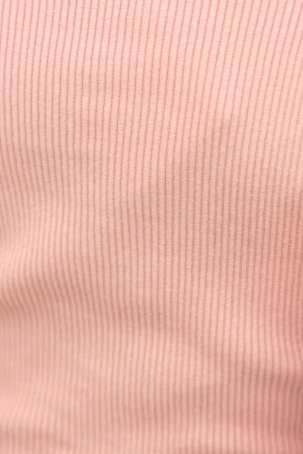 Close-up view of the Selby Top's soft pink ribbed knit fabric, highlighting its stretch and texture.