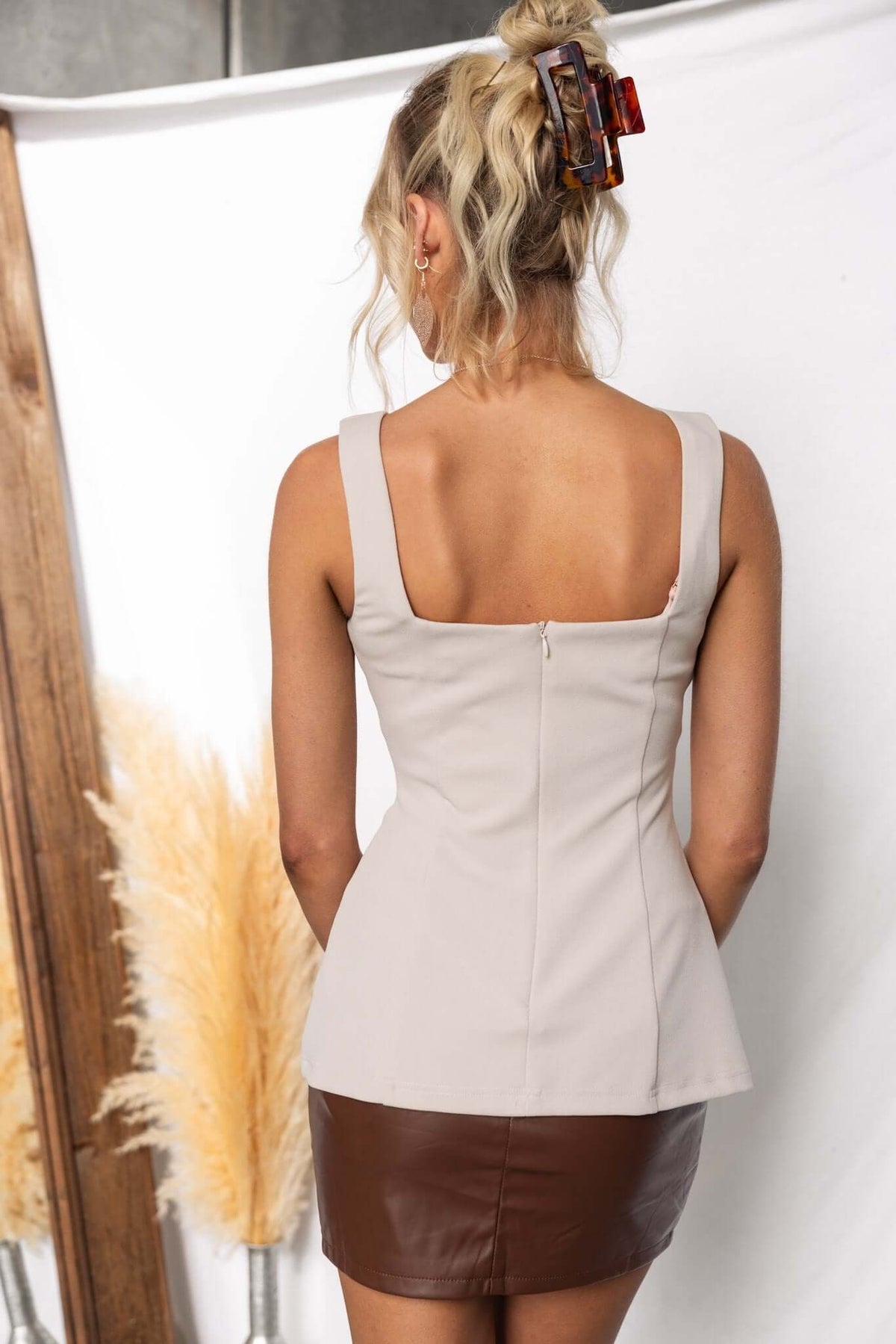 Beige Helena Top with high neckline and back zip, paired with a brown skirt, styled for a chic look.