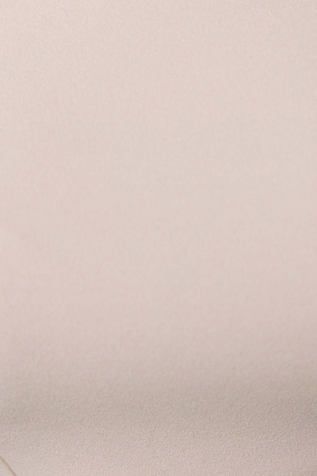 Close-up of soft beige crepe fabric, showcasing smooth texture and stretch for the Helena Top.