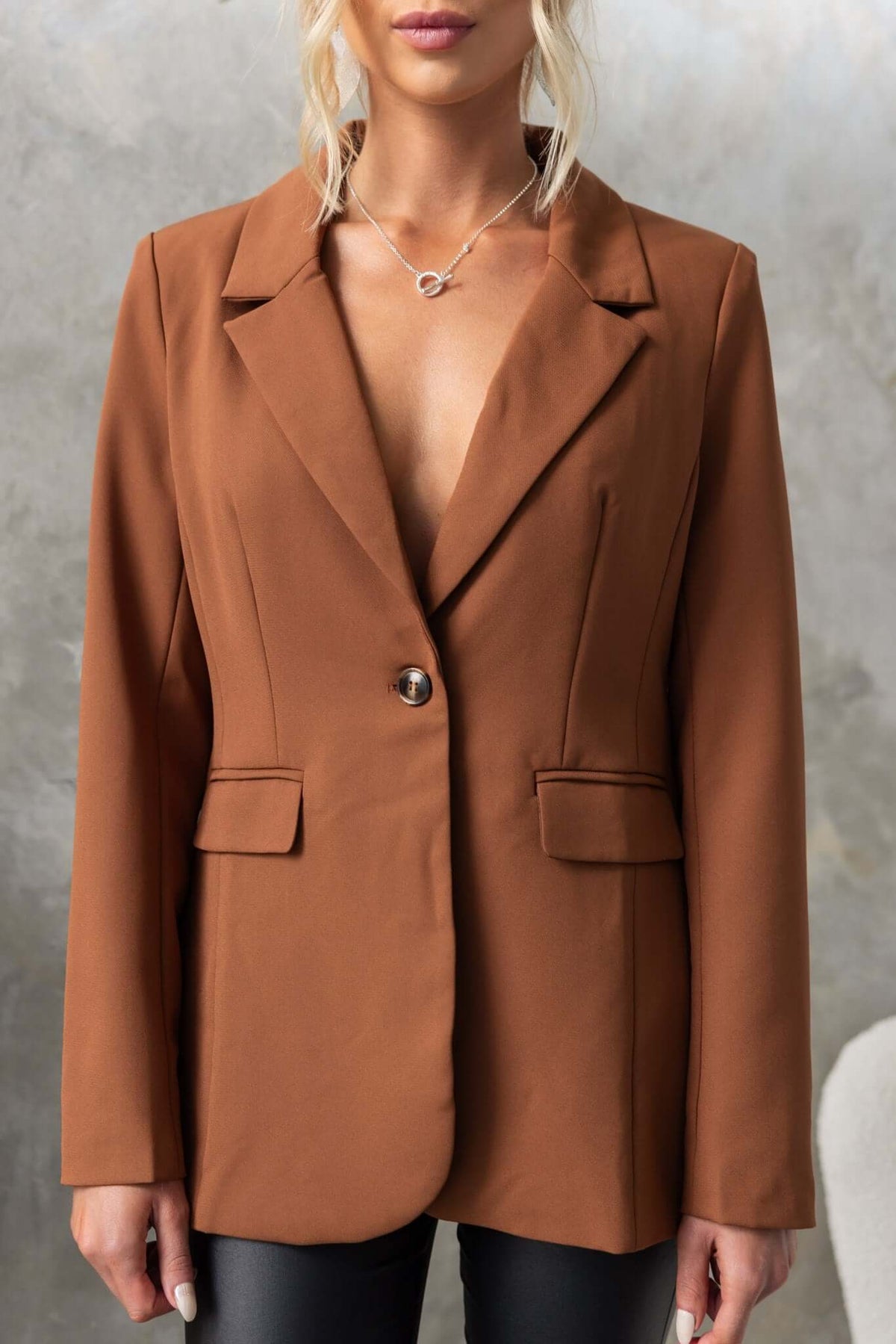 Desio Blazer in brown, featuring a front button, pockets, and shoulder pads for a stylish look.