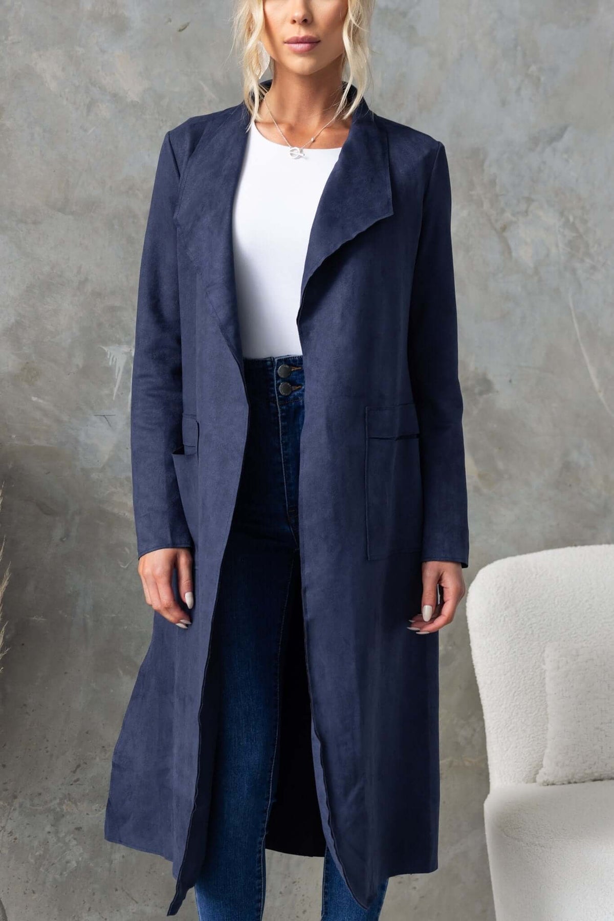 Women's longline navy suede look coat with draping lapel, pockets, and raw-cut edging, perfect for stylish layering.