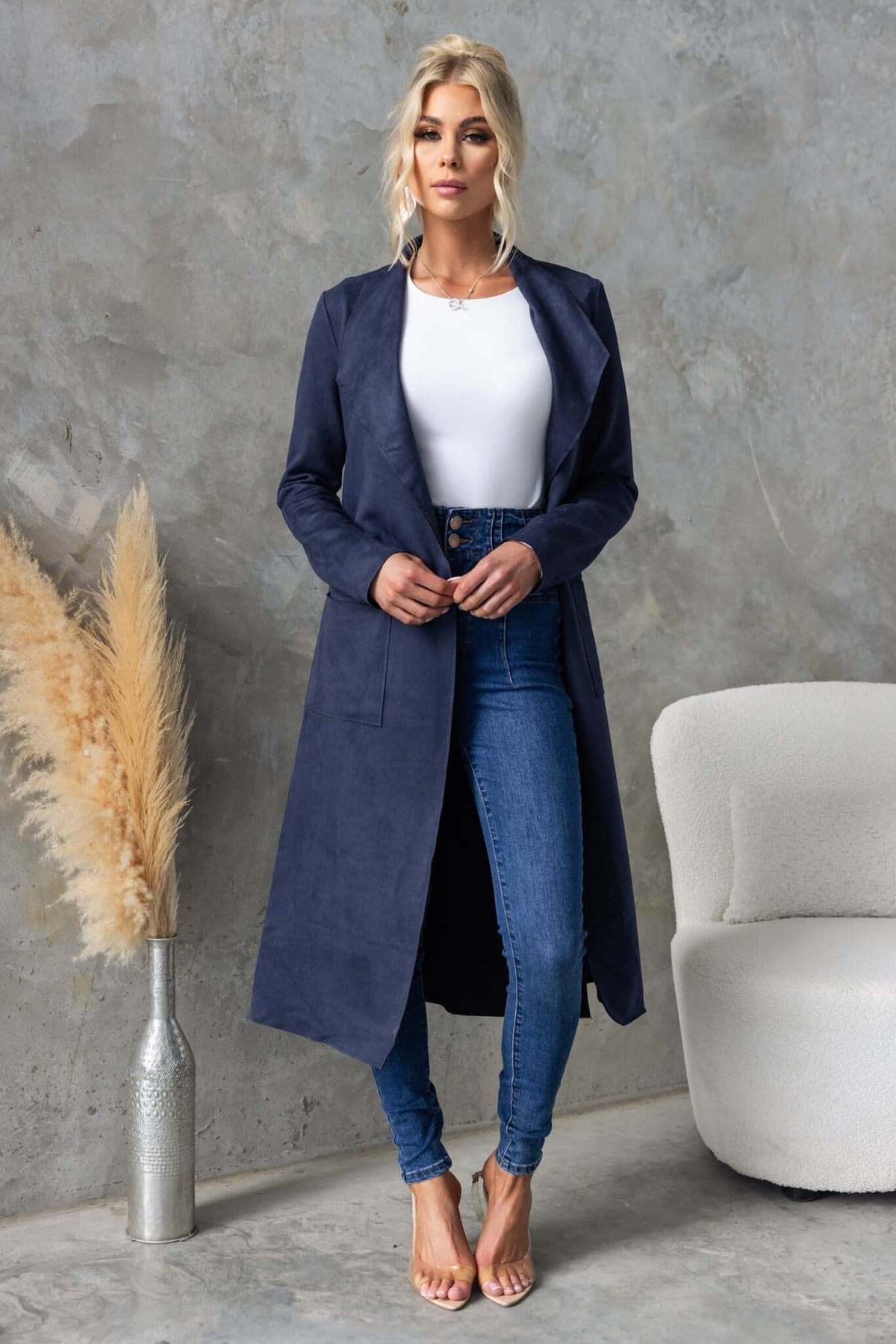 Longline navy Hayley coat with draping lapel, slits, and pockets, styled with jeans and a white top.