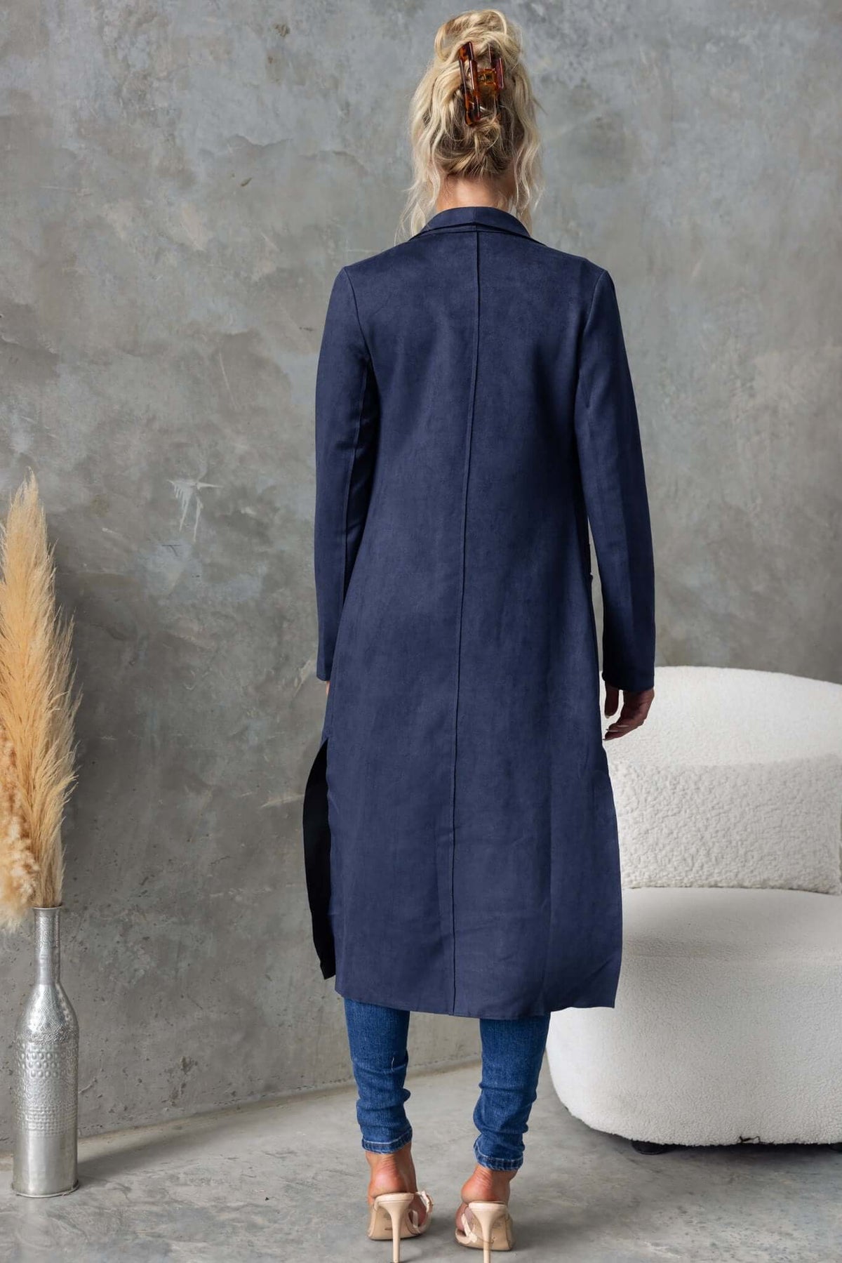 Back view of the Hayley Coat with a longline fit, suede texture, and side slits, styled with casual jeans.