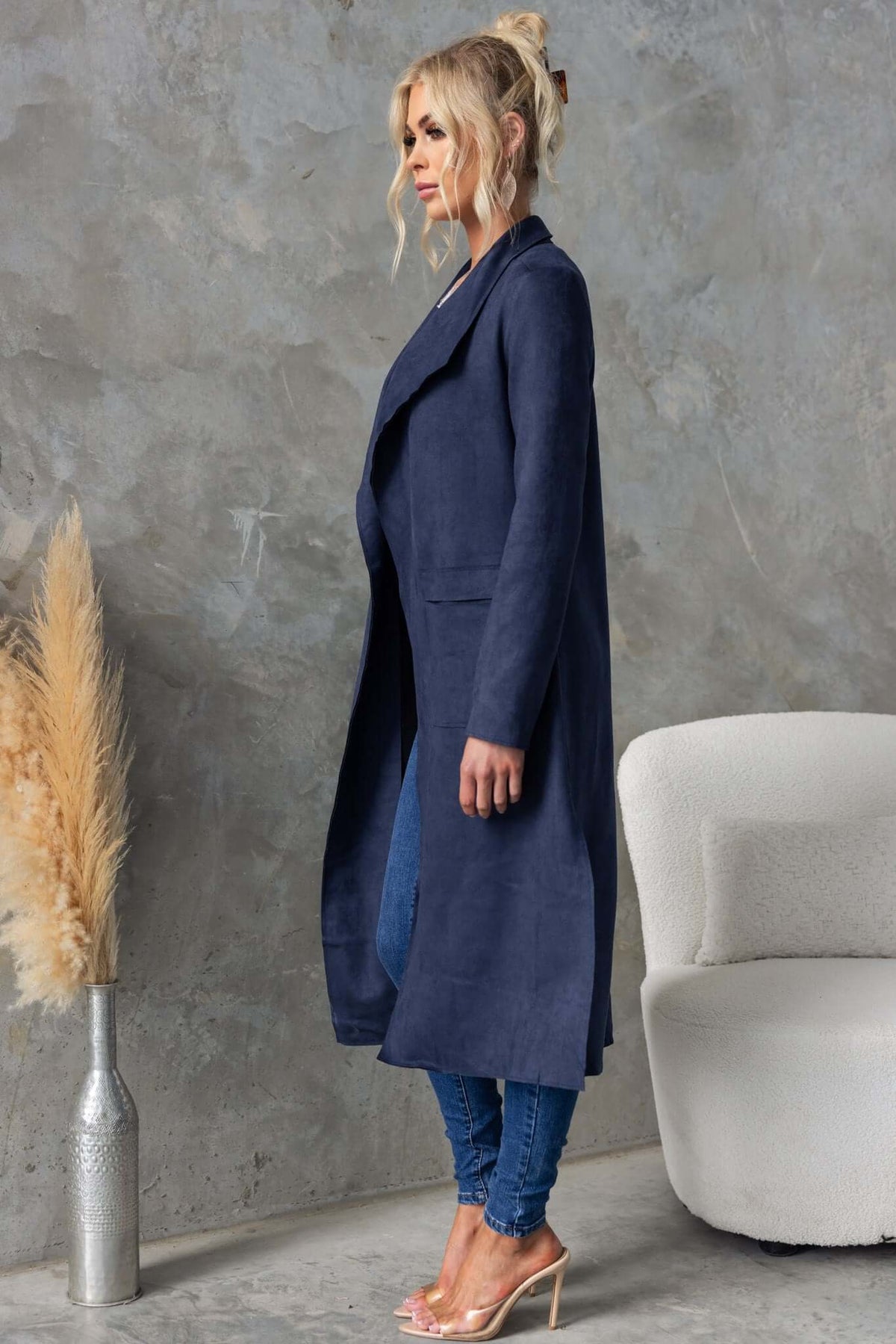 Stylish longline Hayley coat in suede look, featuring draping lapel, side slits and pockets, worn with denim outfit.