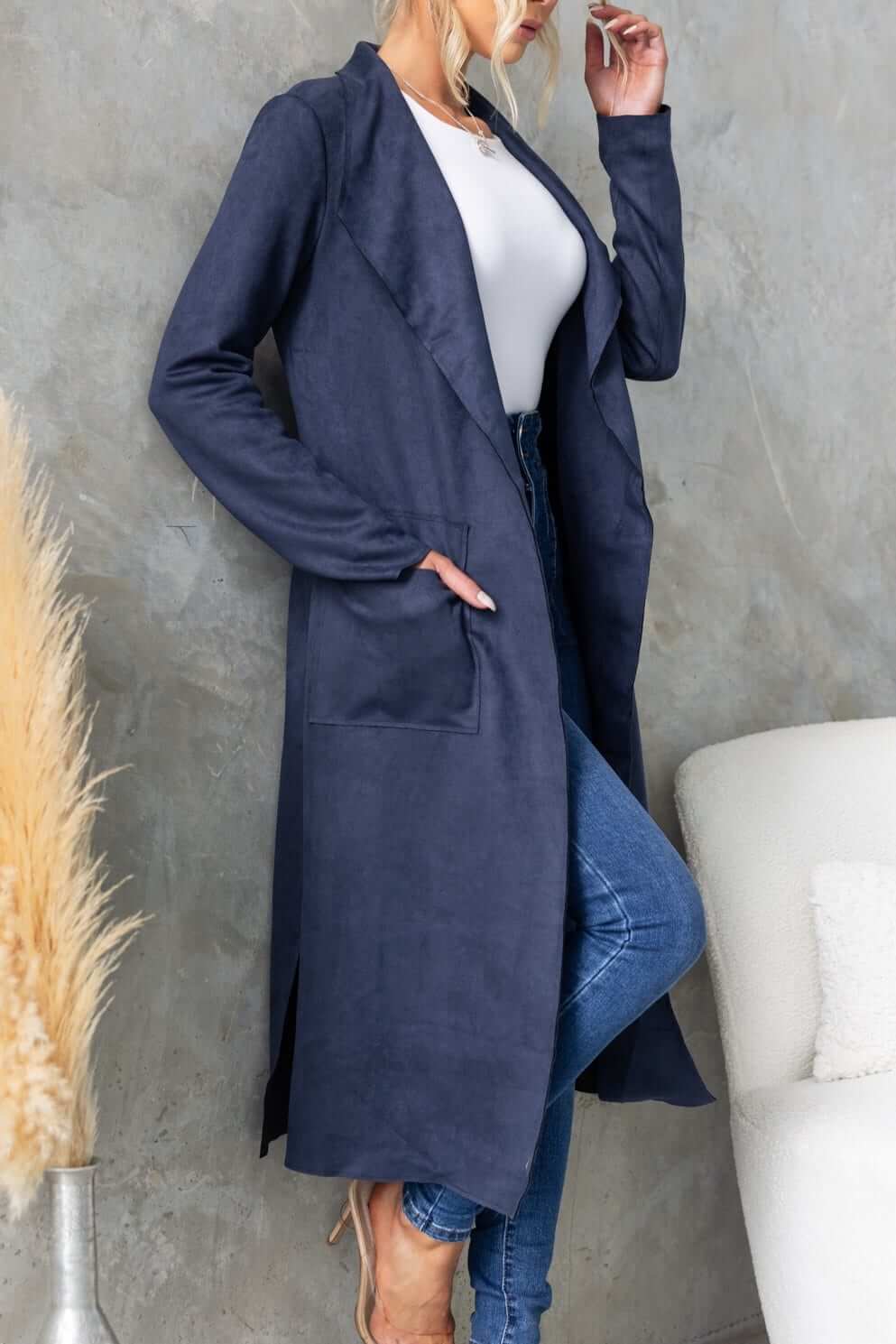 Model wearing Hayley Coat in navy suede look, showcasing draping lapel and side slits, styled with casual outfit.