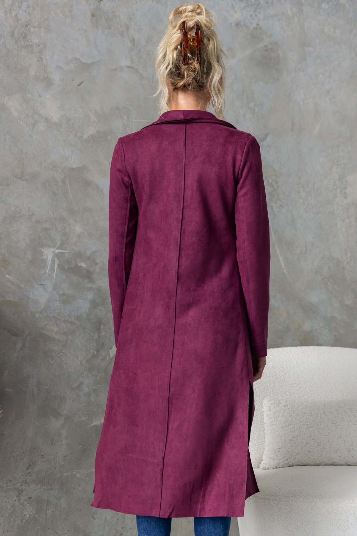 Back view of Hayley Coat in rich plum color with longline fit and draping lapel details, showcasing raw-cut edging.
