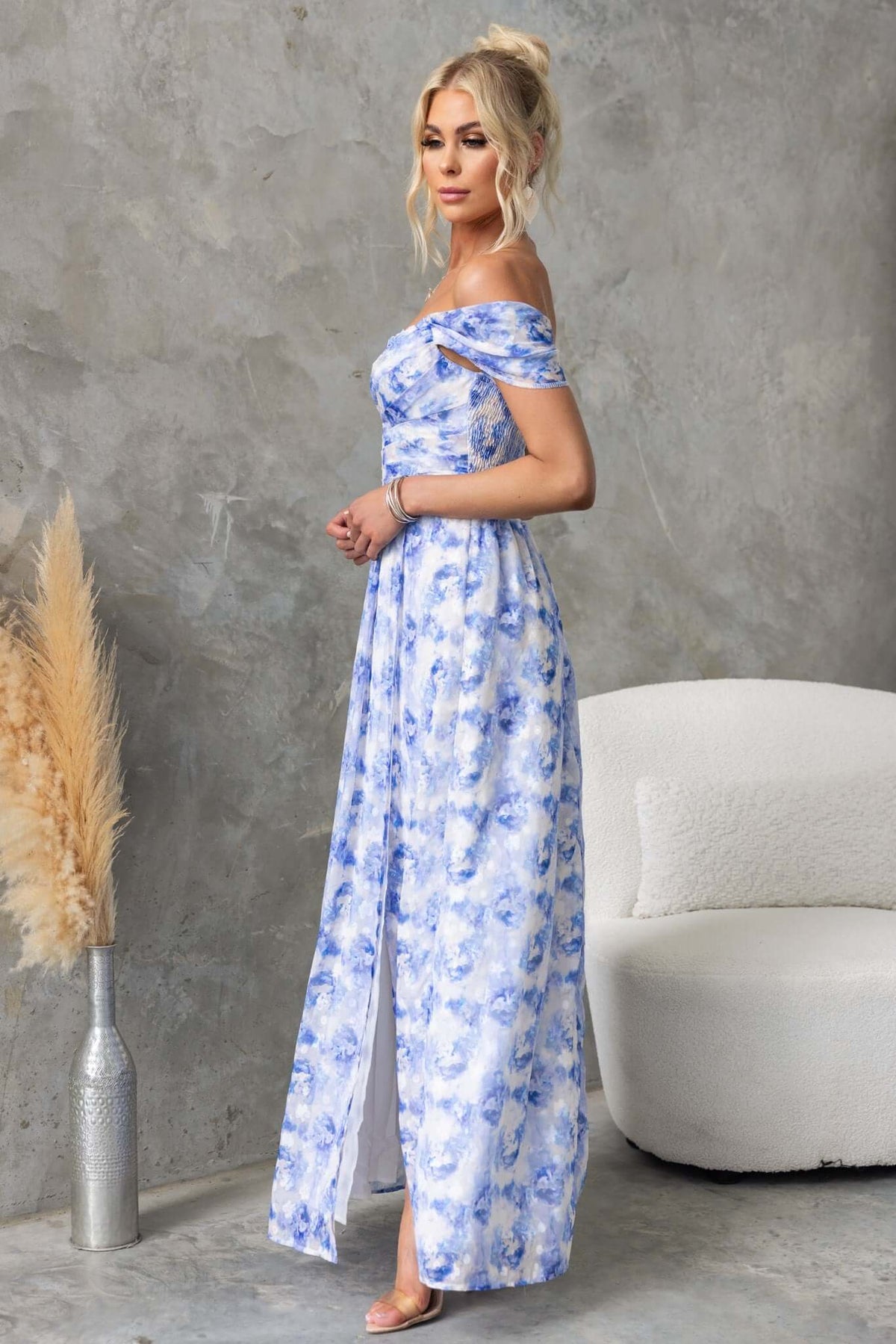 Joan Maxi Dress in blue floral chiffon, featuring off-shoulder style, side slit, and a flowing design.
