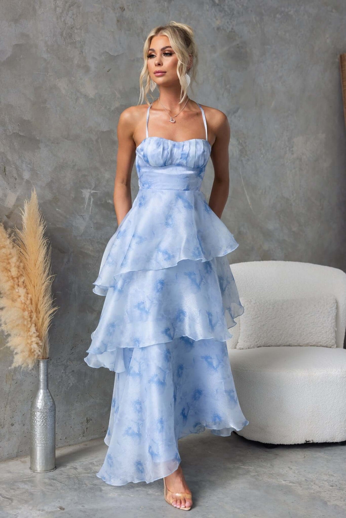 Kirsti Maxi Dress in blue chiffon with adjustable straps and ruffle skirt, styled on model against neutral backdrop.