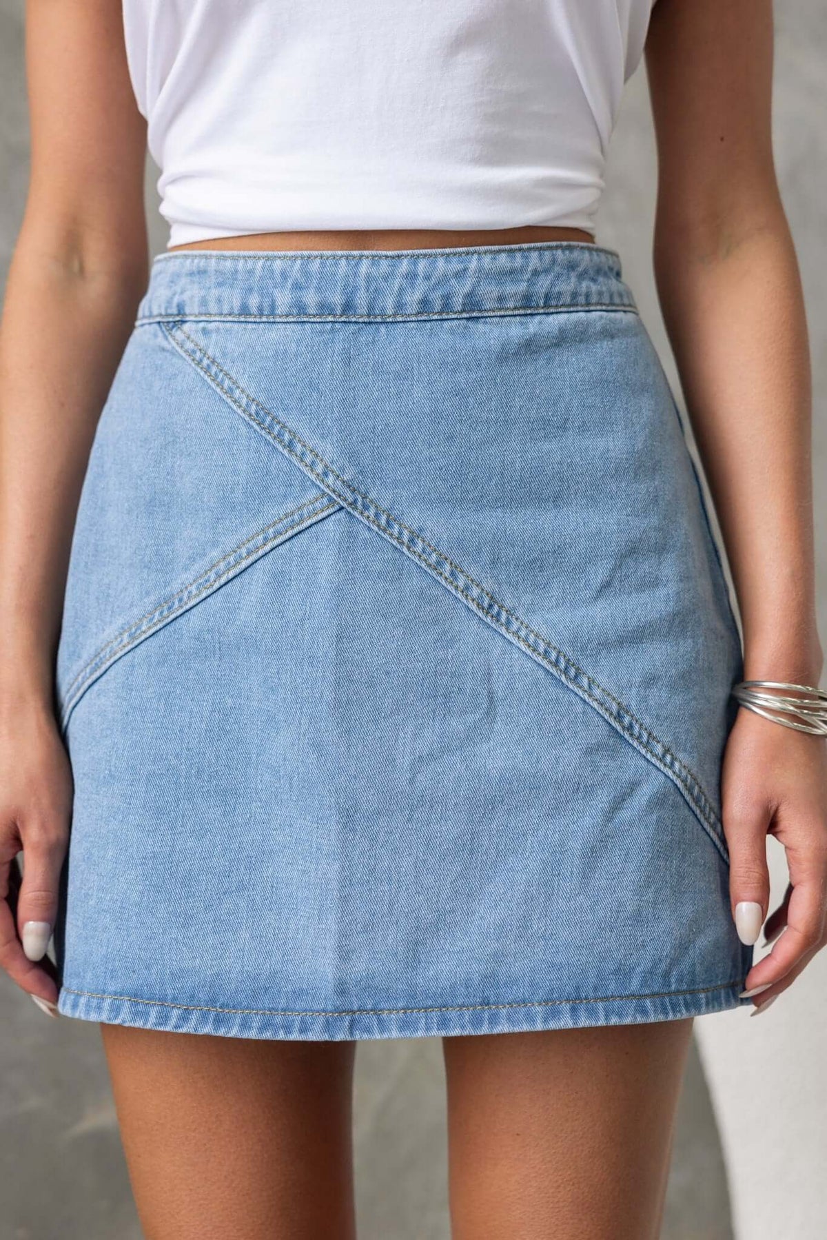 Lizzie Denim Skirt featuring a mid-high waist fit with a zipper at the back, styled for a chic summer look.