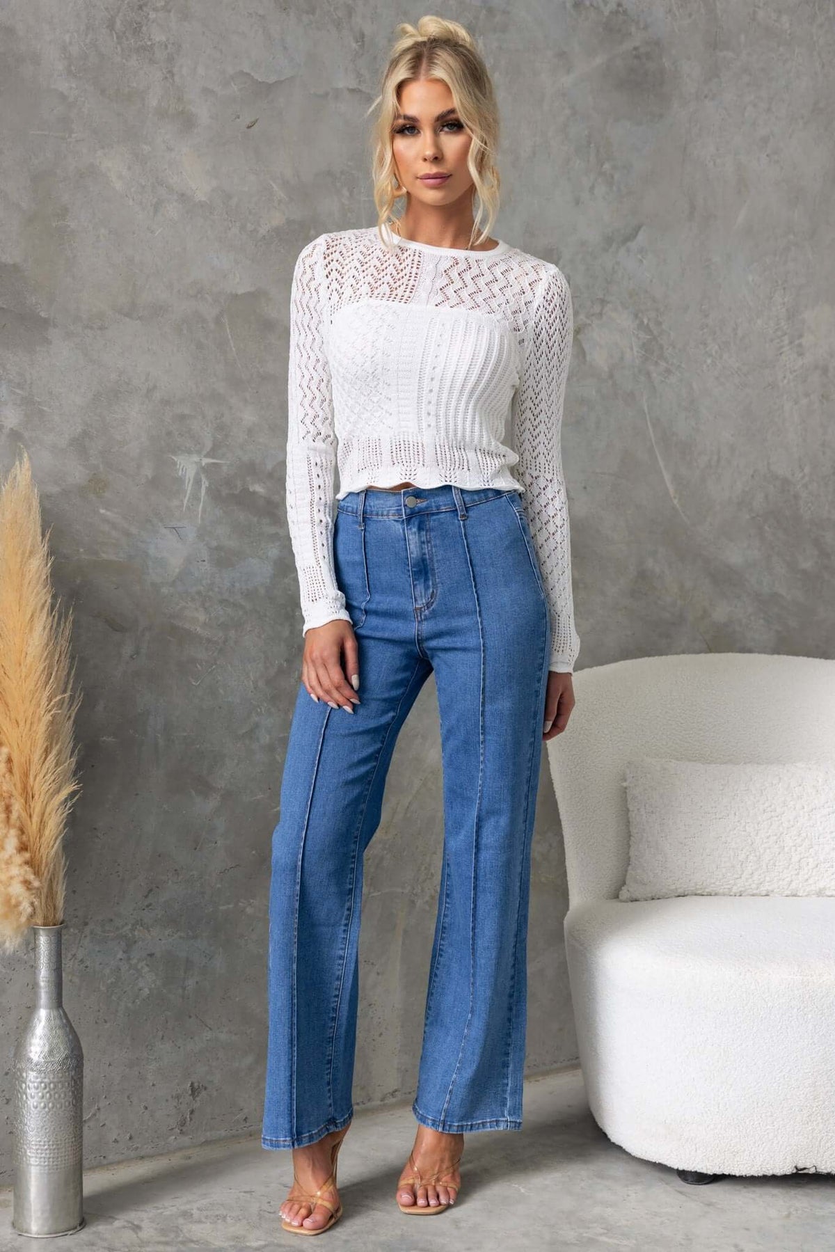 Model wearing Daffy Jeans in mid-high waist fit, paired with a white top, showcasing wide-leg denim style.