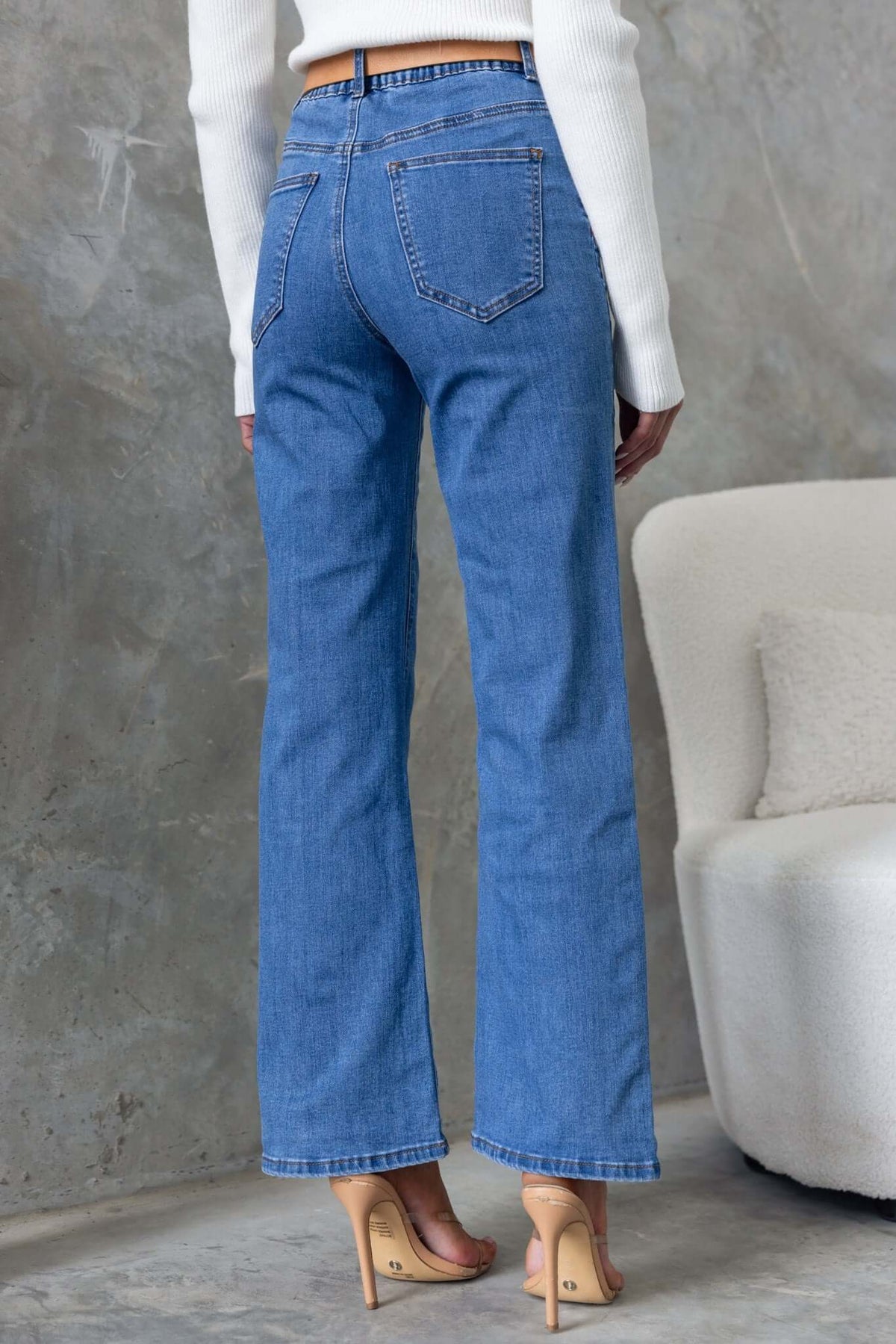 Back view of Daffy Jeans in light blue with a mid-high waist and wide legs, styled with a fitted top.