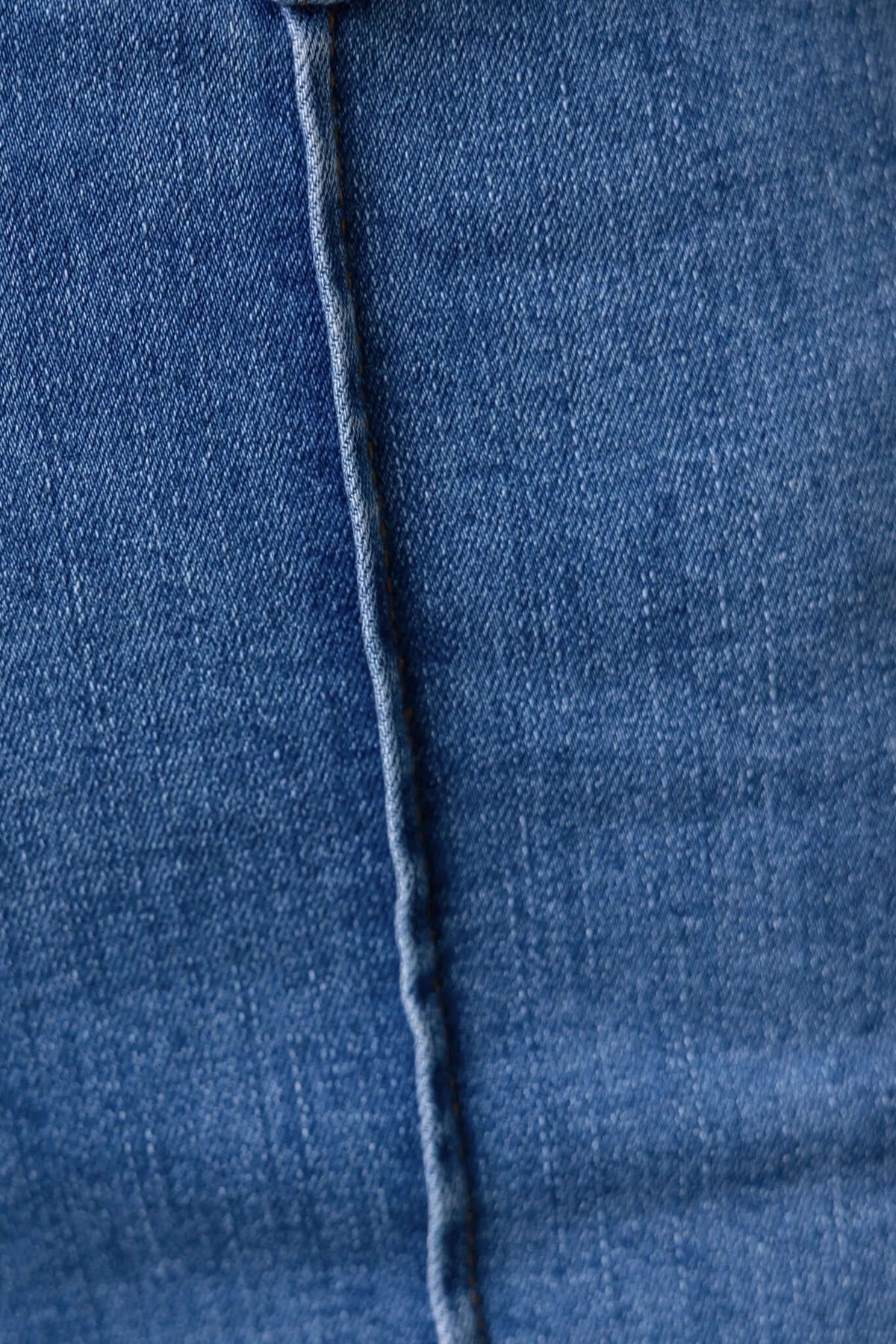 Close-up of Daffy Jeans fabric texture showcasing mid-high waist and denim stitch detail.