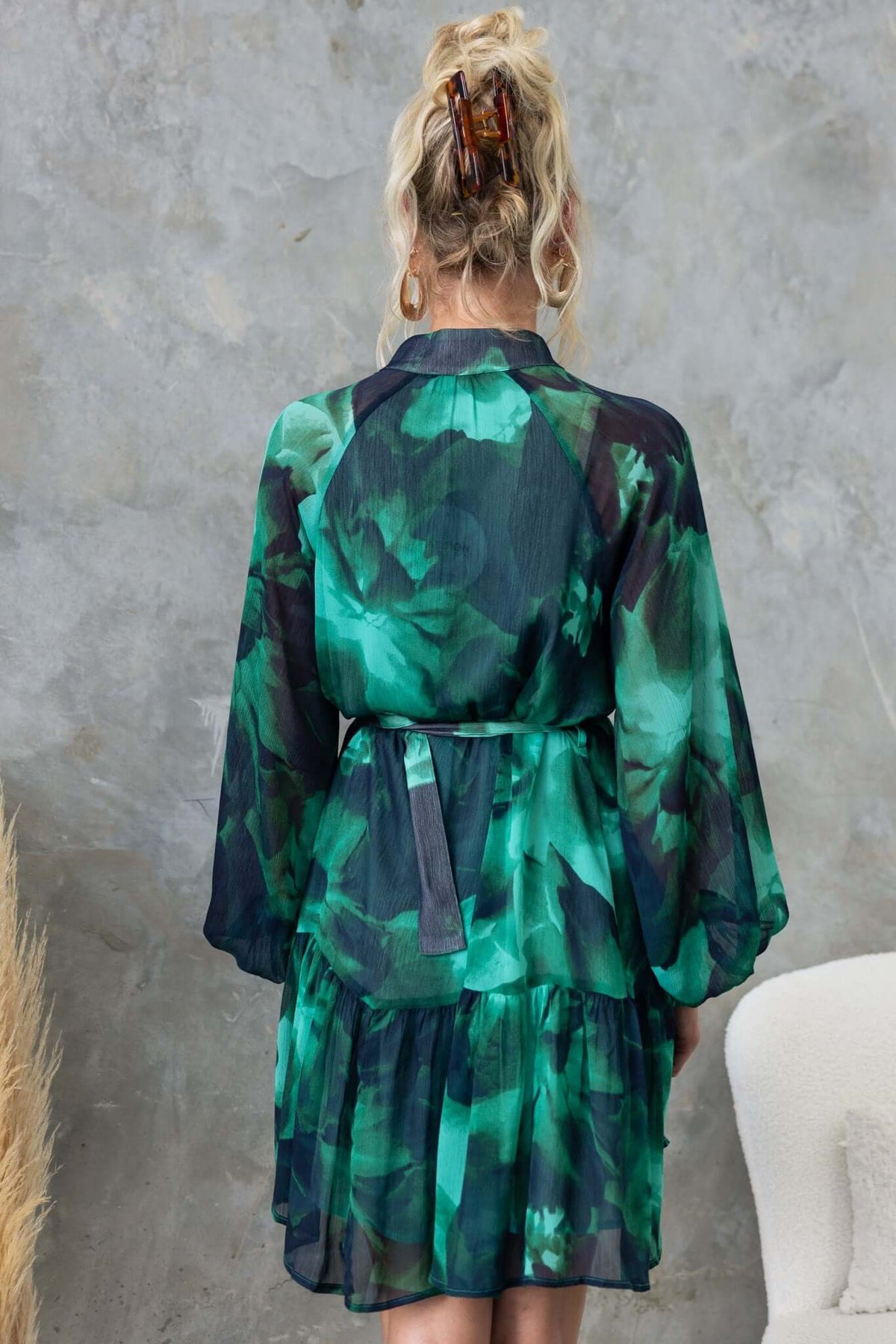 Back view of Orazio Dress in green floral chiffon with high neckline, elastic cuffs, and removable belt.