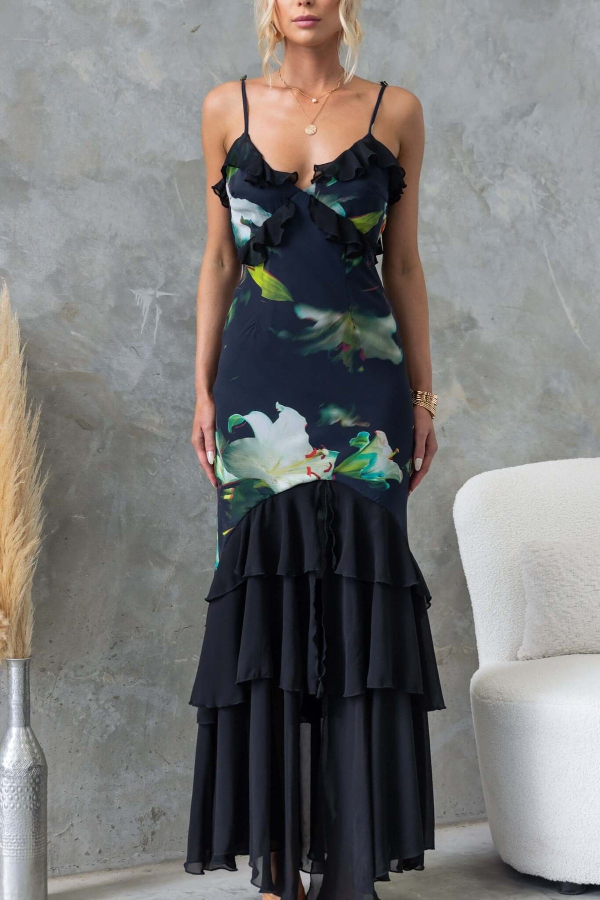 Black maxi dress with floral design, ruffles, adjustable straps, and front split, perfect for elegant occasions.