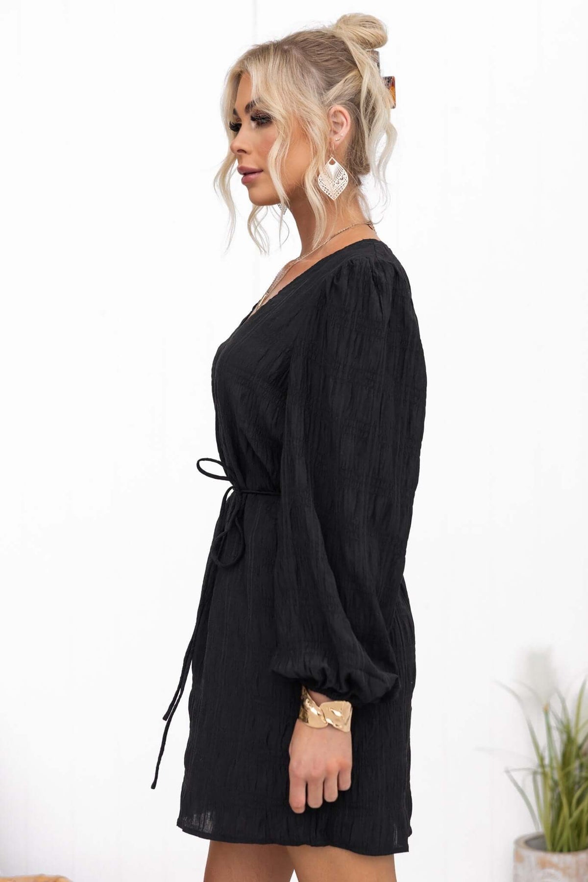 Black Davis Dress with V-neckline, removable tie, elastic sleeves, and pockets, worn by model.