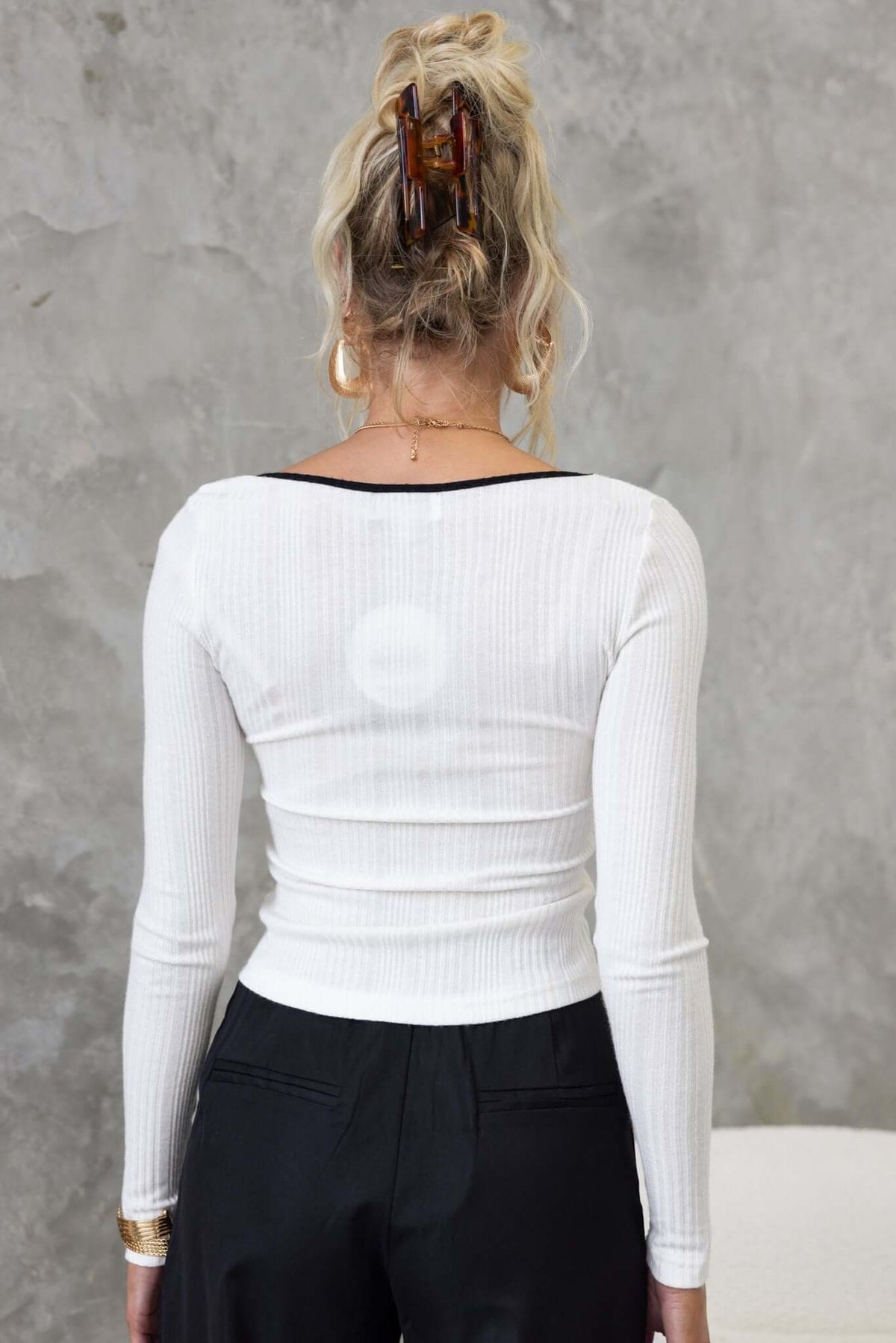 Back view of a woman wearing a white ribbed Rayna Top, showcasing its round neckline and fitted style.