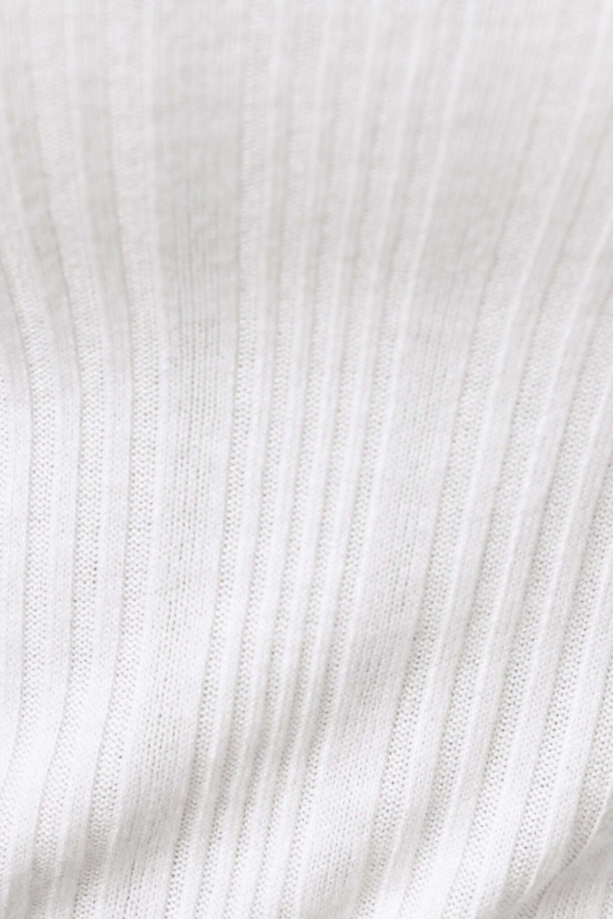 Close-up of ribbed white fabric for the Rayna Top, showcasing its soft texture and stretch material.