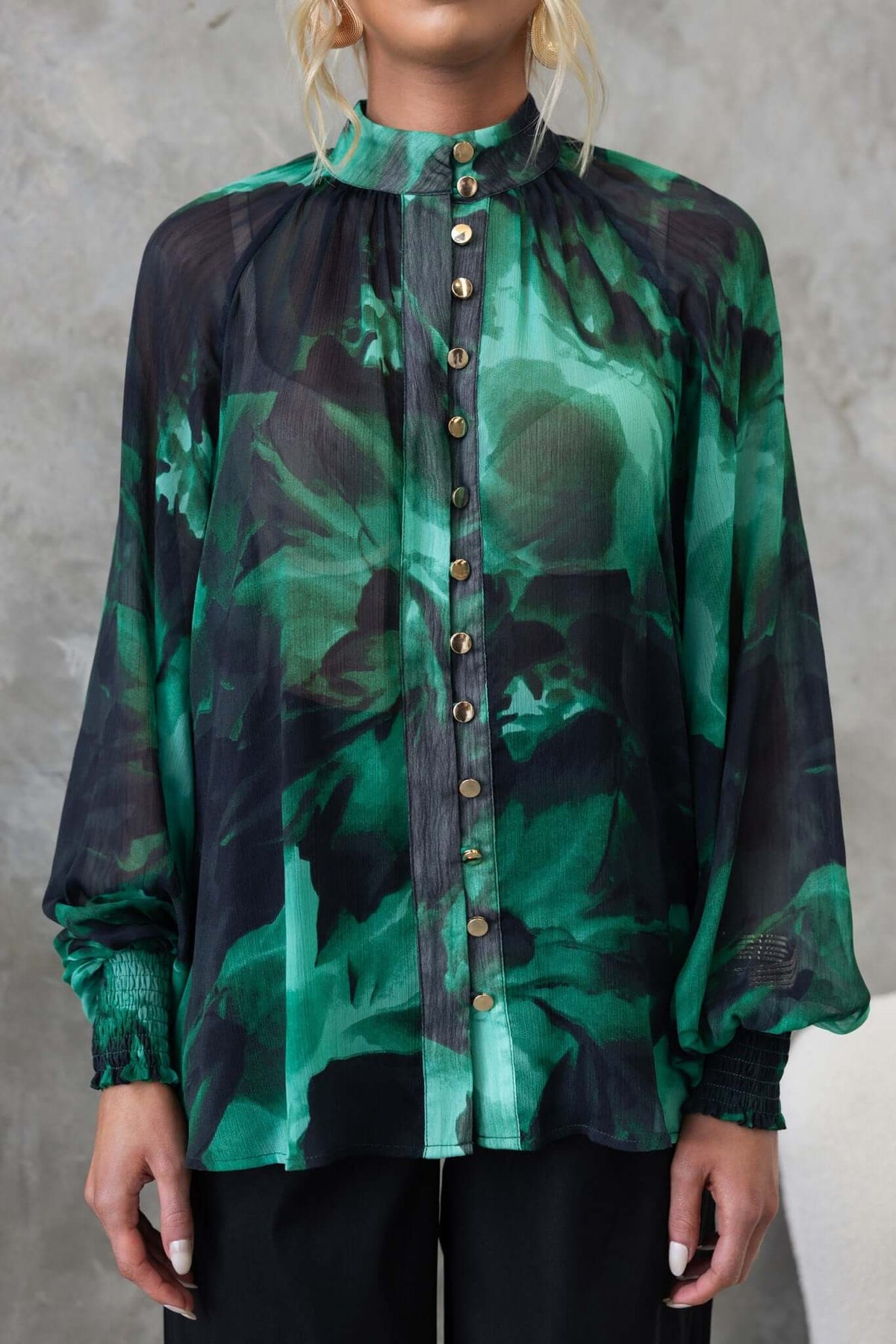 Orazio Top featuring high neckline, button-up front, and chiffon material in vibrant green floral pattern.