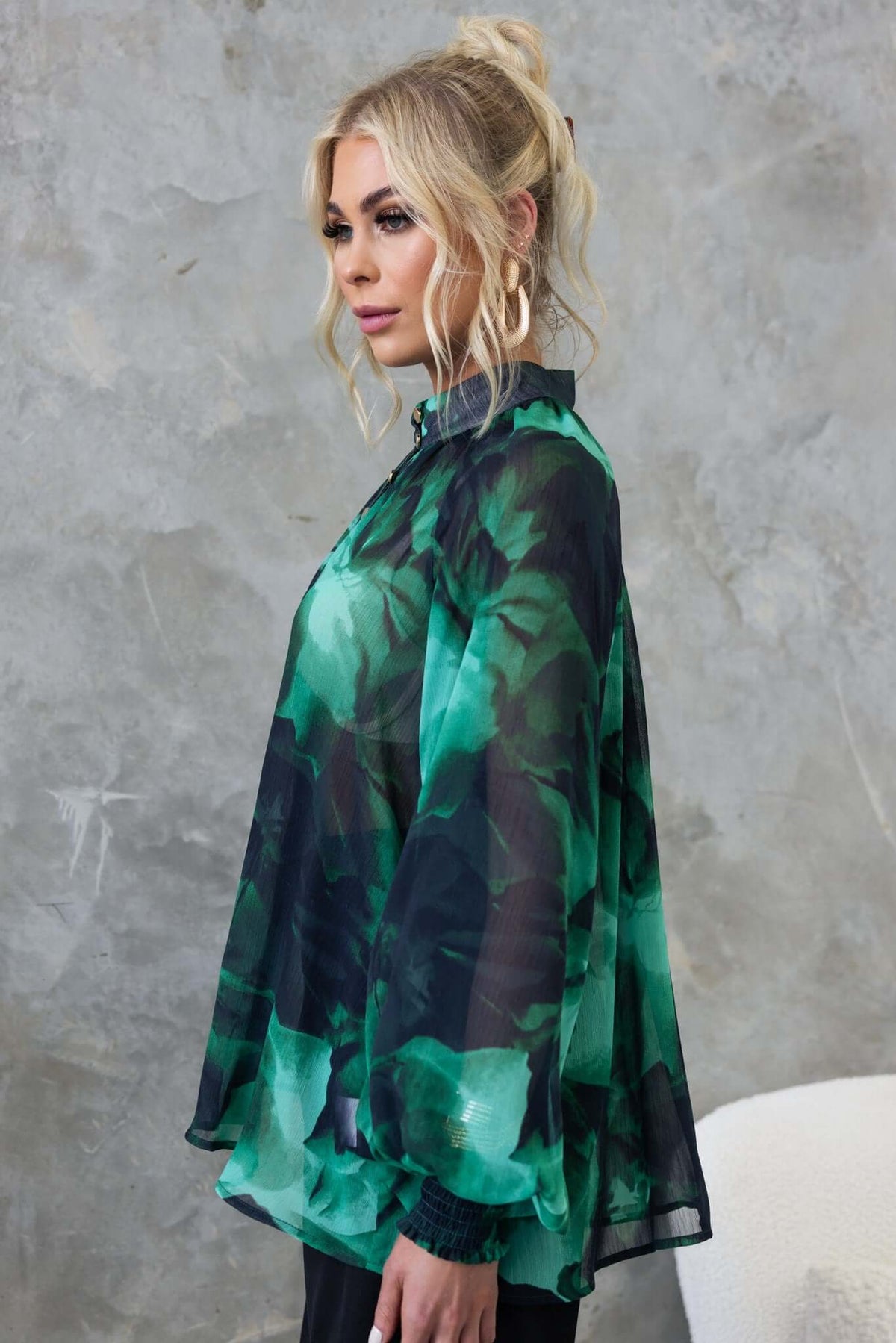 Orazio Top featuring a high neckline, button-up front, and elegant chiffon material in green tones.